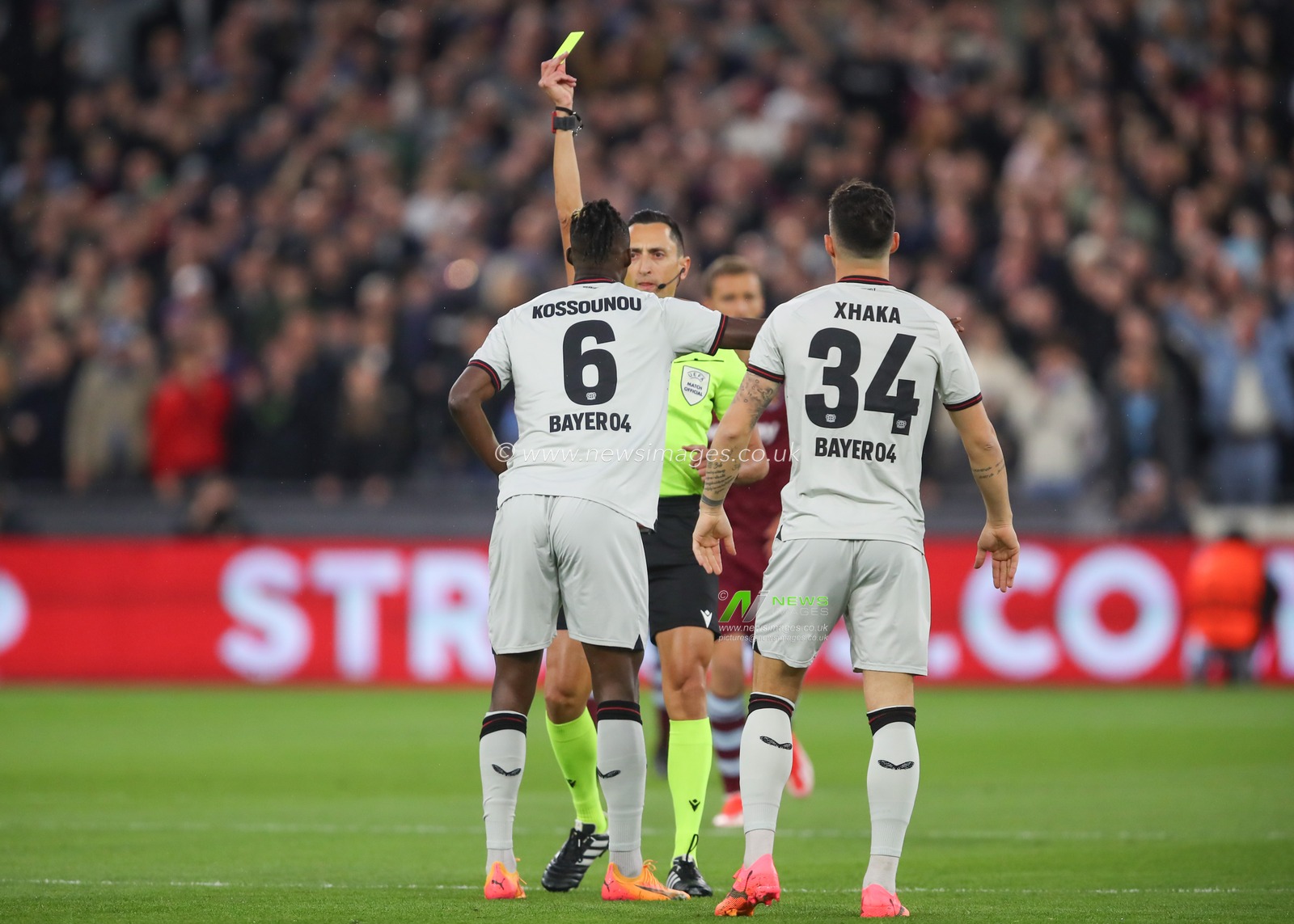 Odilon Kossounou of Bayer Leverkusen receives a yellow card from referee Jose Maria Sanchez Martinez,  during the UEFA Europa League Quarter-Final match West Ham United vs Bayer 04 Leverkusen at London Stadium, London, United Kingdom, 18th April 2024

(Photo by Gareth Evans/News Images)