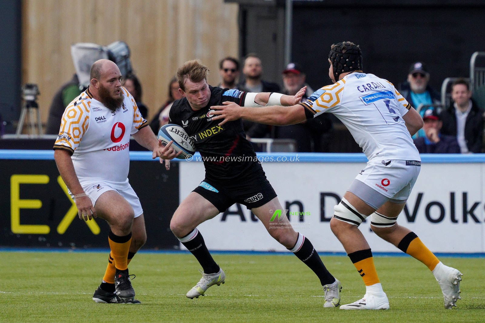 Nick Tompkins #12 of Saracens manages to slip past  Tim Cardall #5 of Wasps