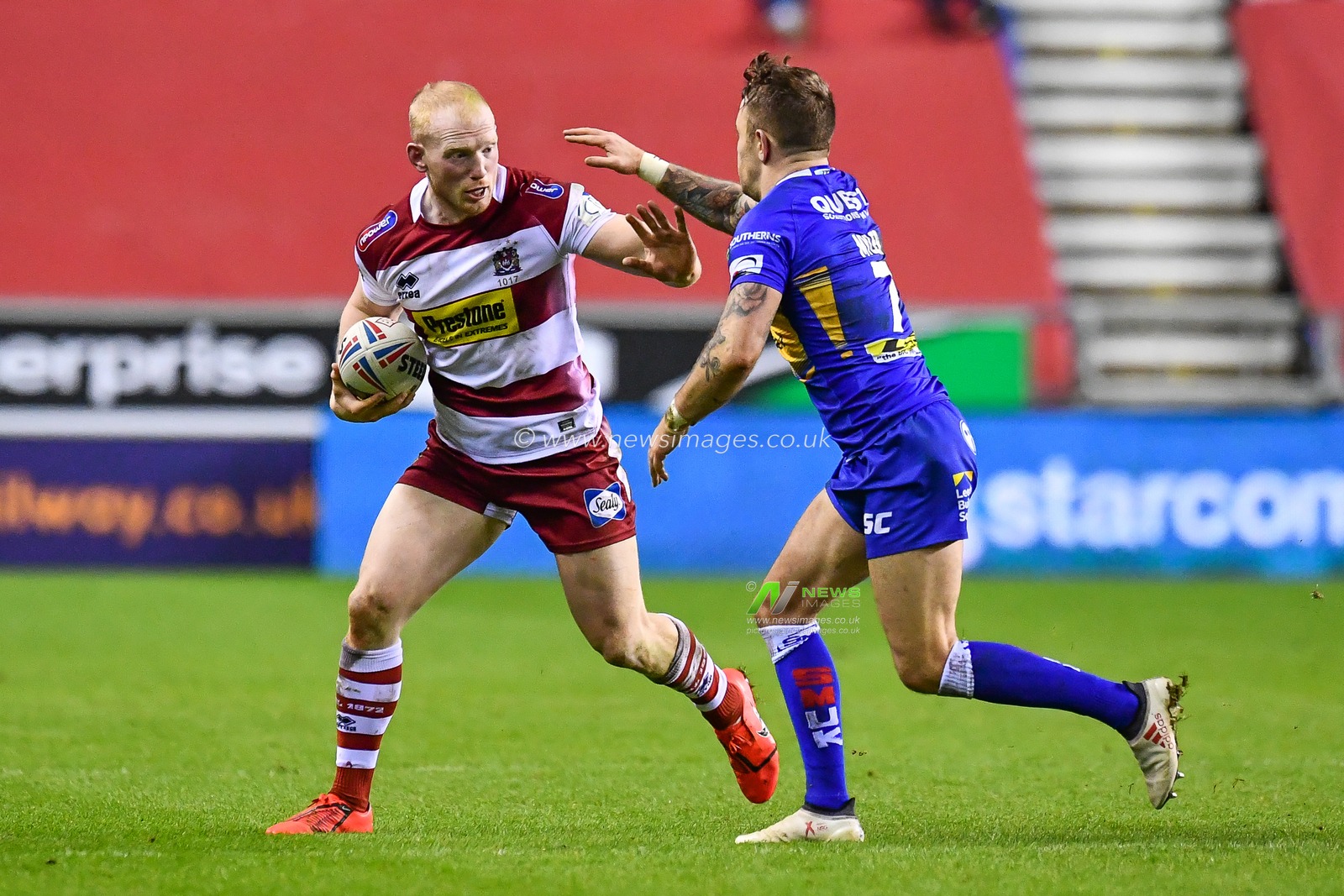 8th February  2019 , DW Stadium, Wigan, England;  Betfred Super League, Round 2, Wigan Warriors vs Leeds Rhinos ; Laim Farrell (12) of Wigan Warriors evades the tackle of Richie Myler (7) of Leeds Rhinos 

Credit: Craig Thomas/News Images
