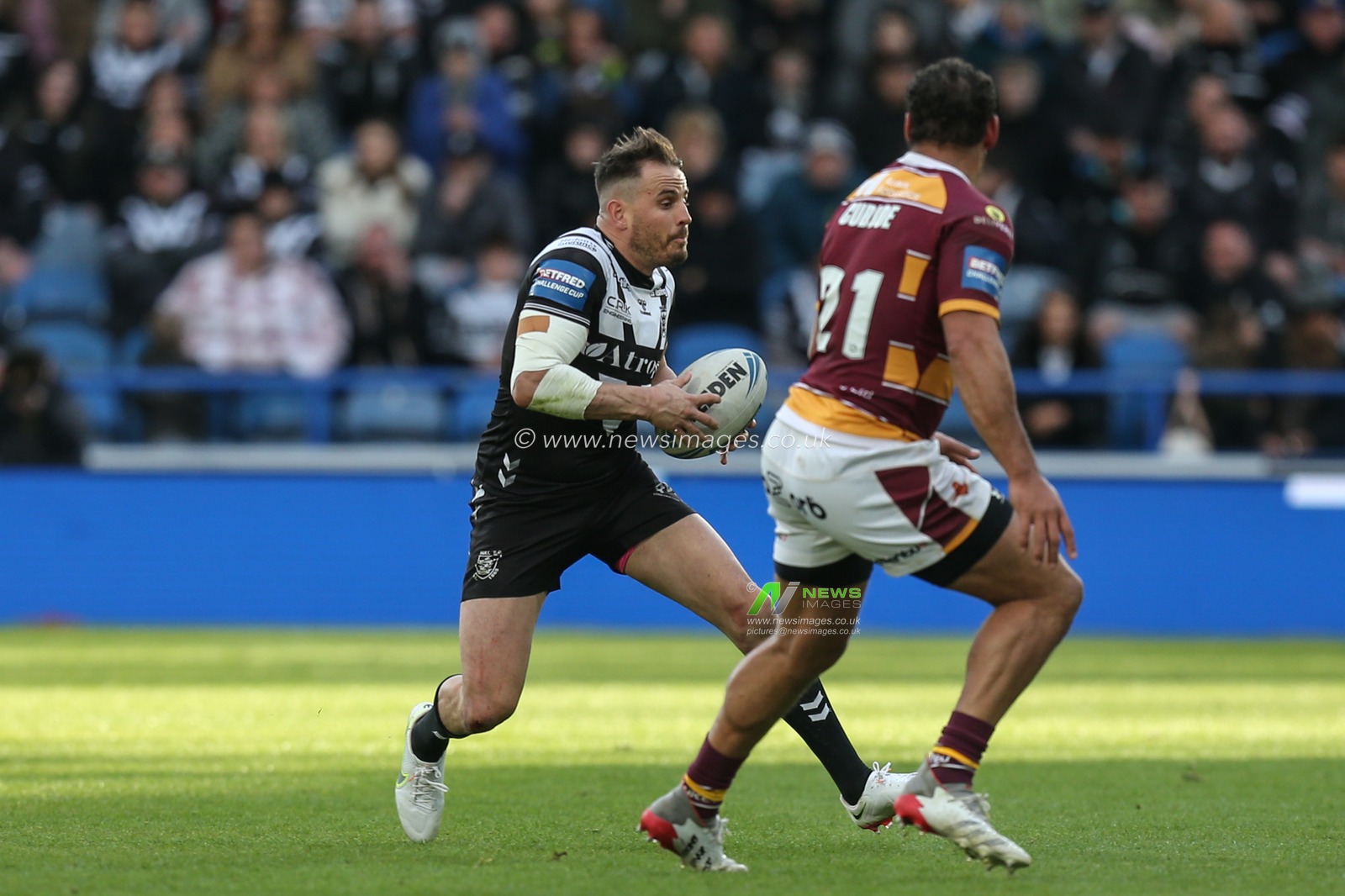 Josh Reynolds #6 of Hull FC looks to go past Leroy Cudjoe #21 of Huddersfield Giants