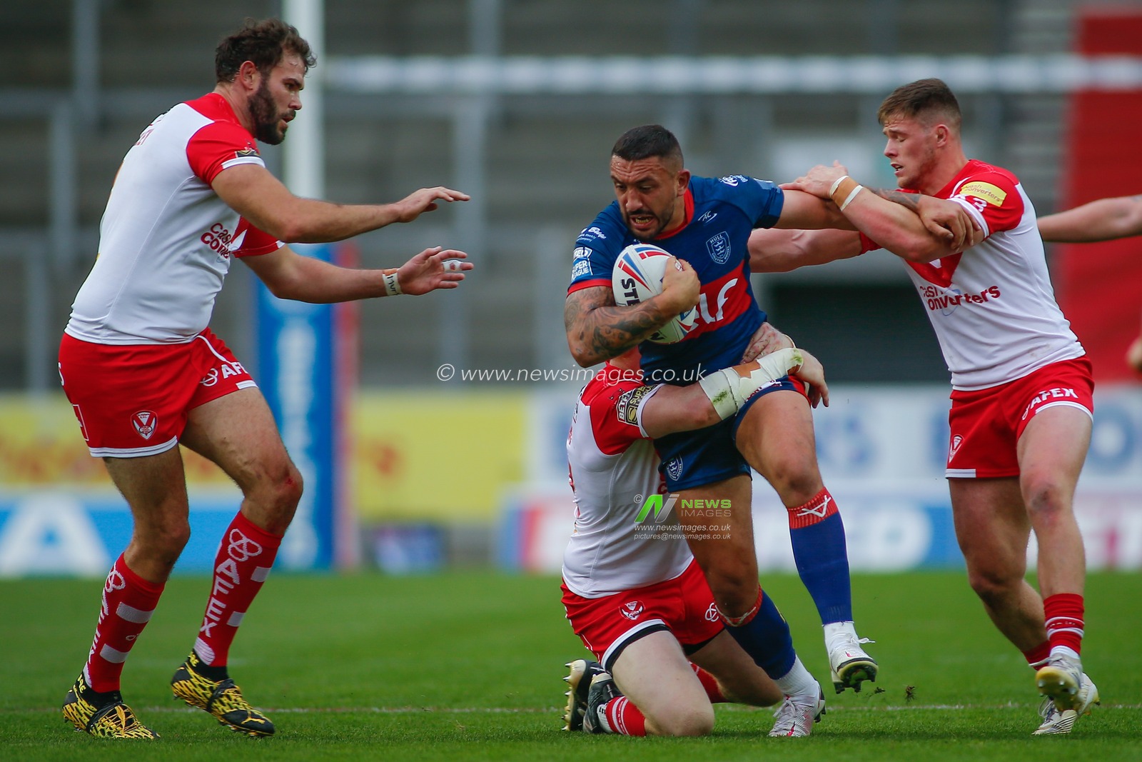 Elliot Minchella (27) of Hull KR tackled by the St Helens defence.