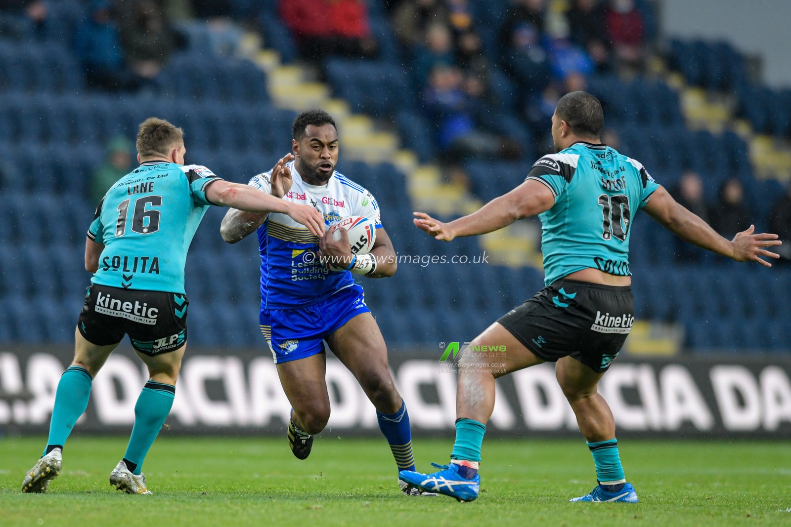 King Vuniyayawa (19) of Leeds Rhinos looks for a way past Jordan Lane (16) of Hull FC and Chris Satae (10) of Hull FC