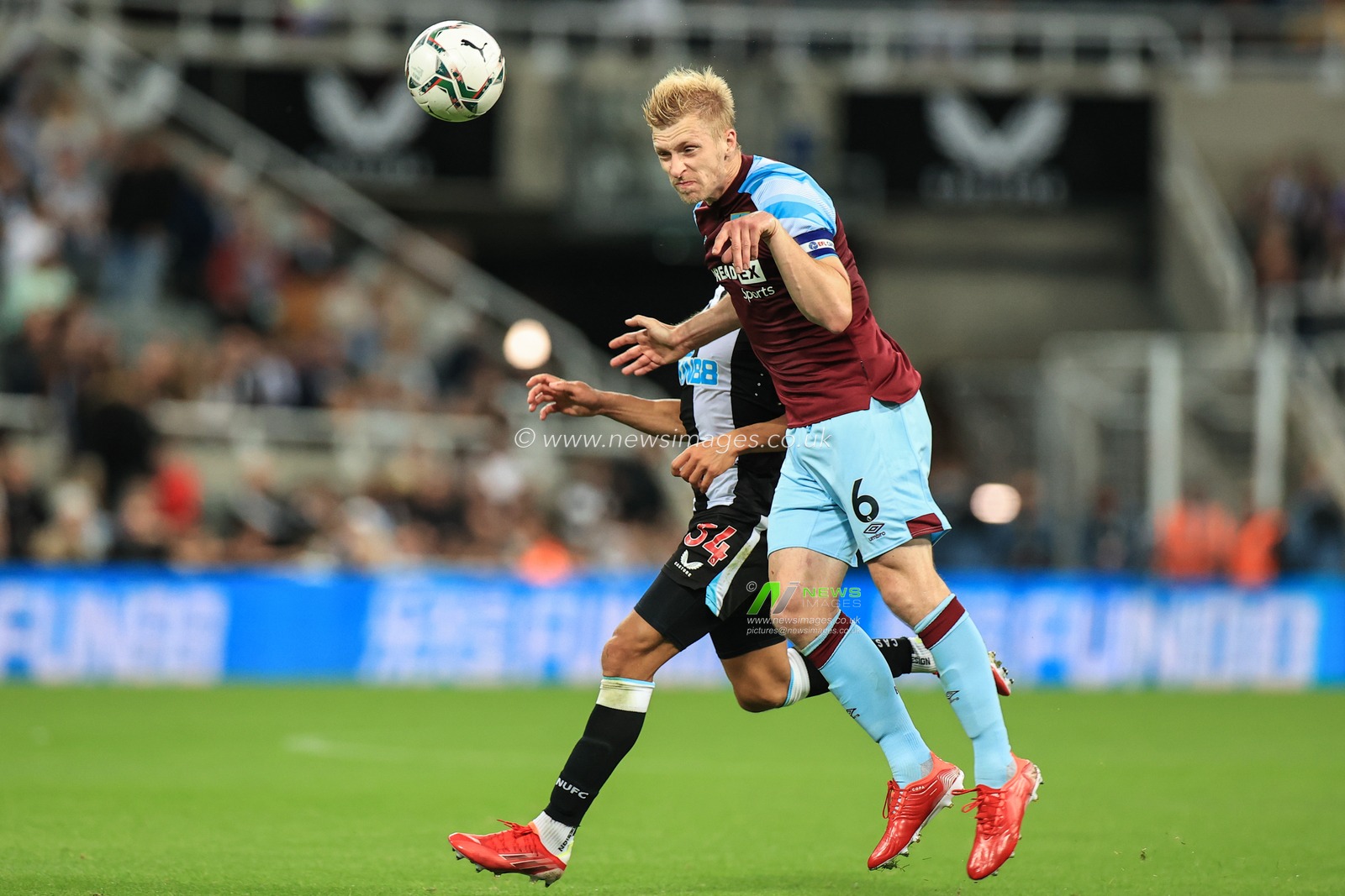 Ben Mee #6 of Burnley heads the ball back to Wayne Hennessey #13 of Burnley while under pressure from Dwight Gayle #34 of Newcastle United