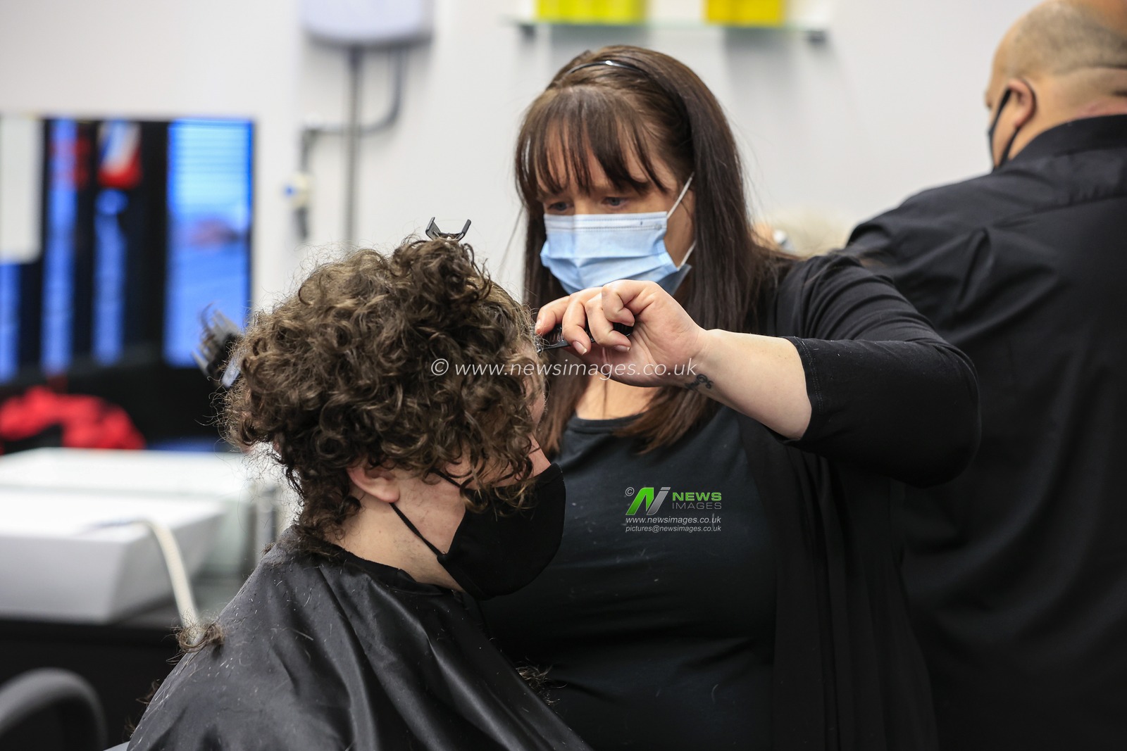 Emma cuts a customer's hair at Henry's Barbershop, High Bridge, Newcastle upon Tyne, as national lockdown restrictions are eased in England