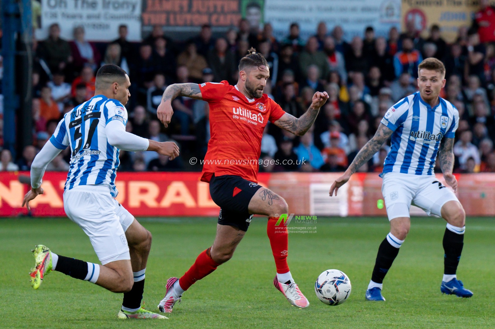 Henri Lansbury #23 of Luton Town under pressure from Jon Russell #37 of Huddersfield Town