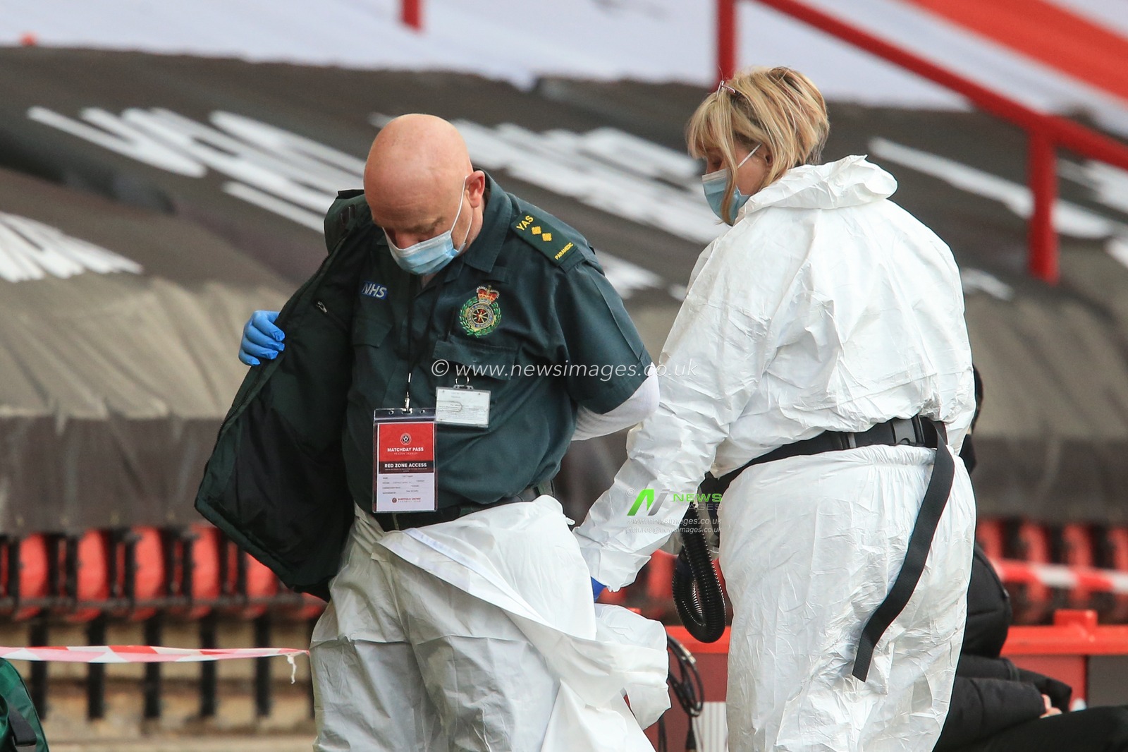 NHS game staff prepare for the game as they dress in white protective suites as part of the Covid 19 protocol in the red zone