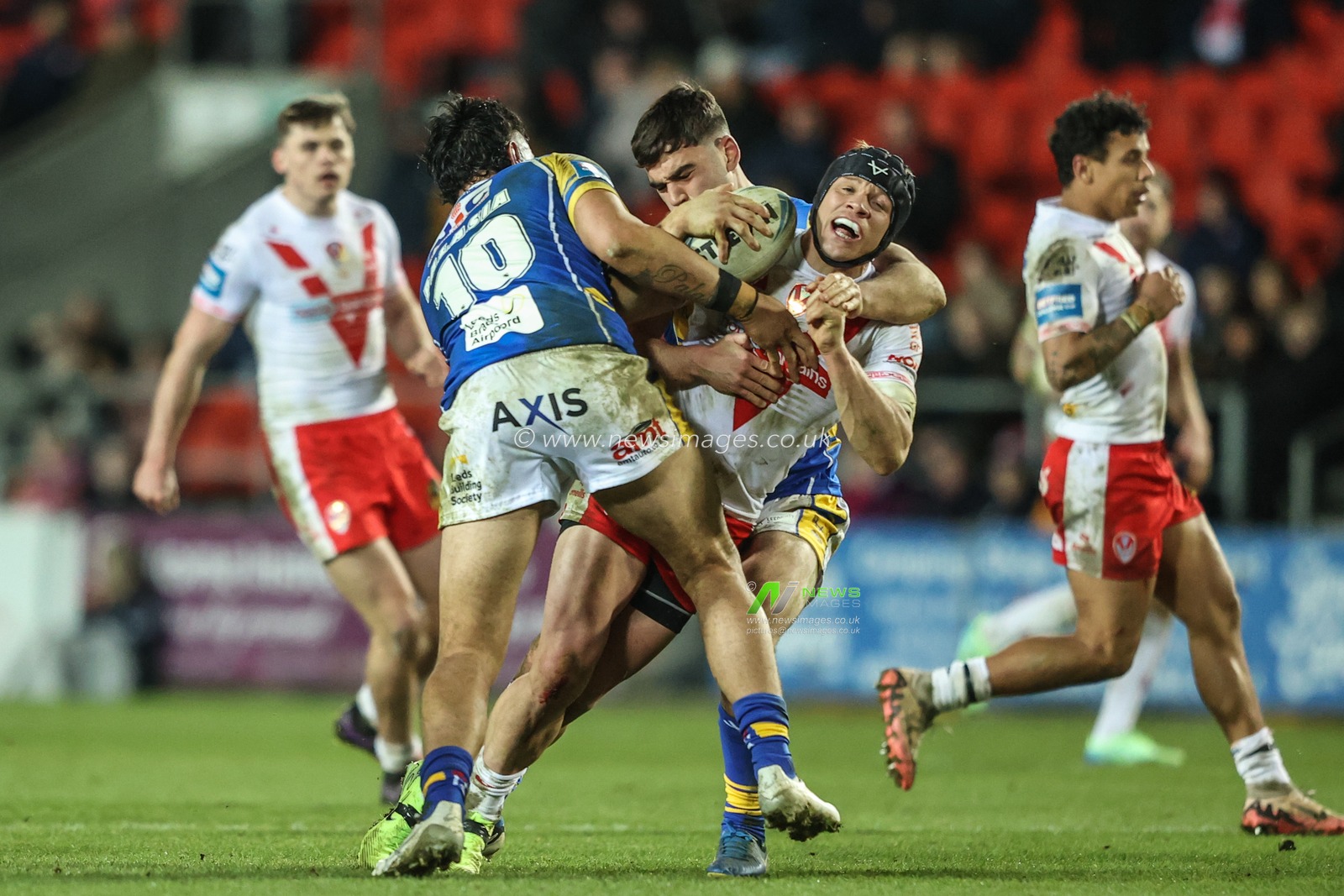 Jonny Lomax of St. Helens is tackled by Keenan Palasia of Leeds Rhinos and Jack Sinfield of Leeds Rhinos during the Betfred Challenge Cup match St Helens vs Leeds Rhinos at Totally Wicked Stadium, St Helens, United Kingdom, 14th March 2025

(Photo by Alfie Cosgrove/News Images)