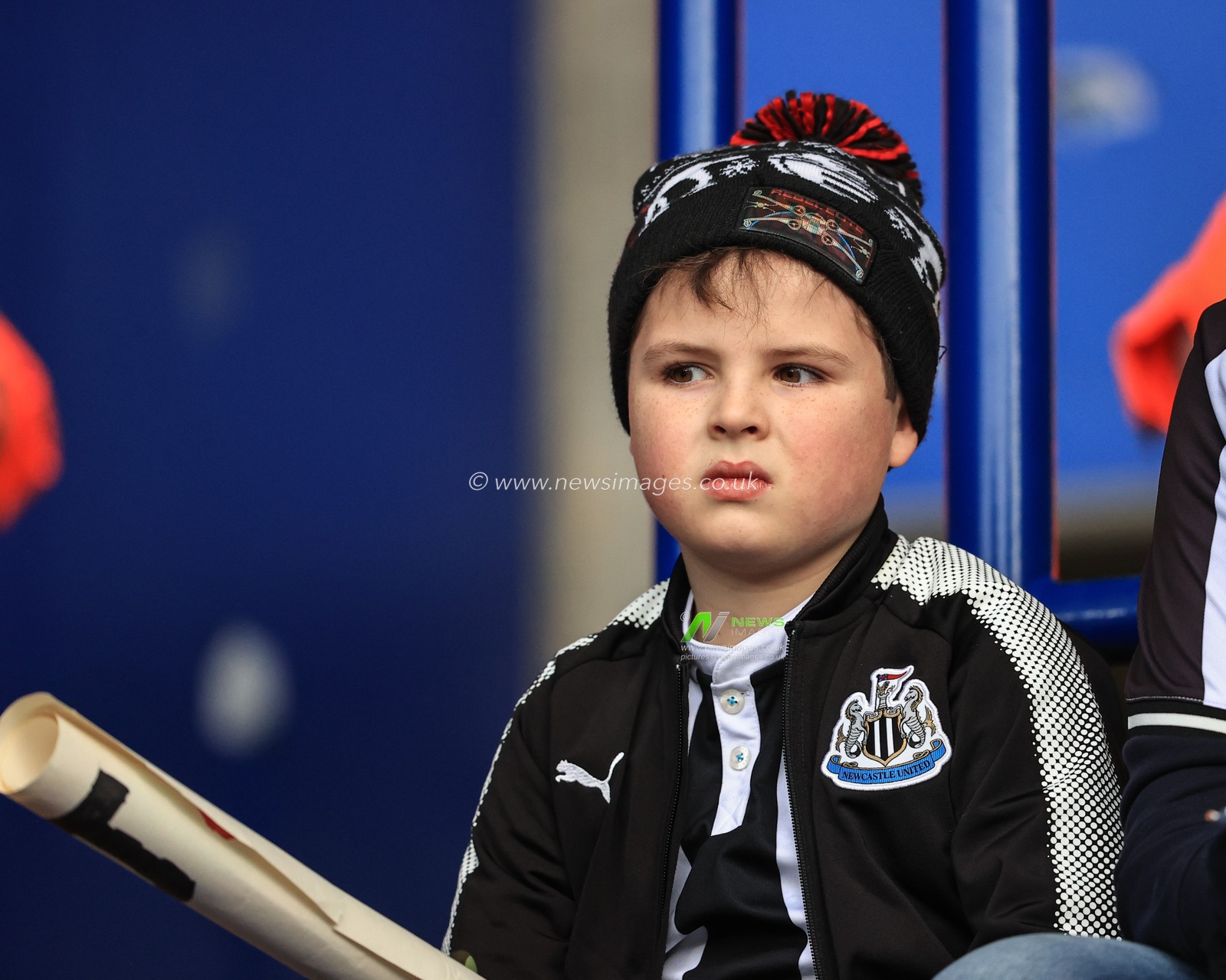 A young Newcastle fan watches his team warm up