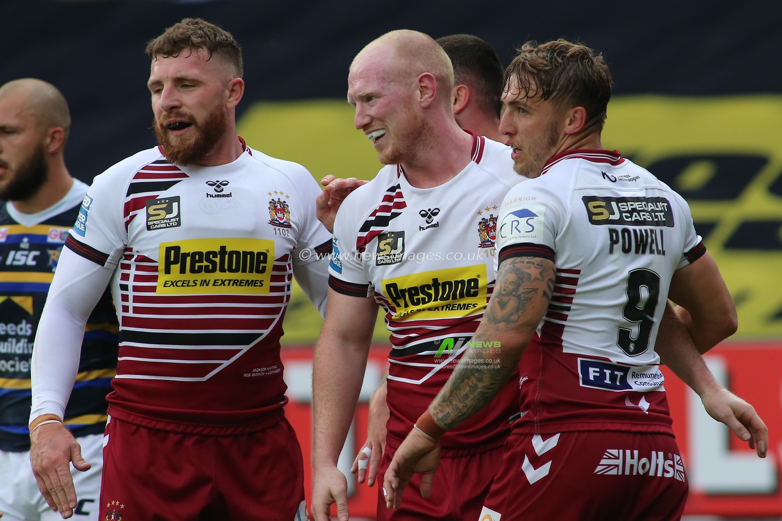 Liam Marshall (C) of Wigan Warriors celebrates scoring his try with team mates Jacksons Hastings (31) and Sam Powell (9).