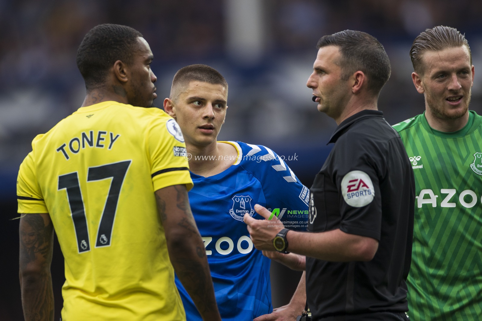 Referee Michael Oliver has a chat with Ivan Toney #17 of Brentford and Vitaly Mykolenko #19 of Everton