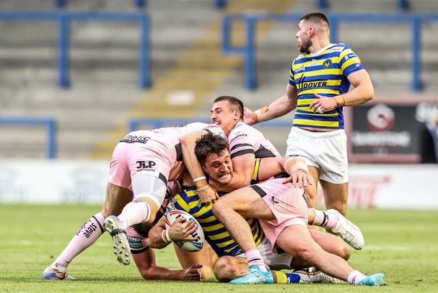 Liam Byrne of Warrington Wolves is tackled by Harvie Hill of Hull FC and Jake Arthur of Hull FC during the Betfred Super League round 13 match Warrington Wolves vs Hull FC at The Halliwell Jones Stadium, Warrington, United Kingdom on 05 June 2026

(Photo by Alfie Cosgrove/News Images)