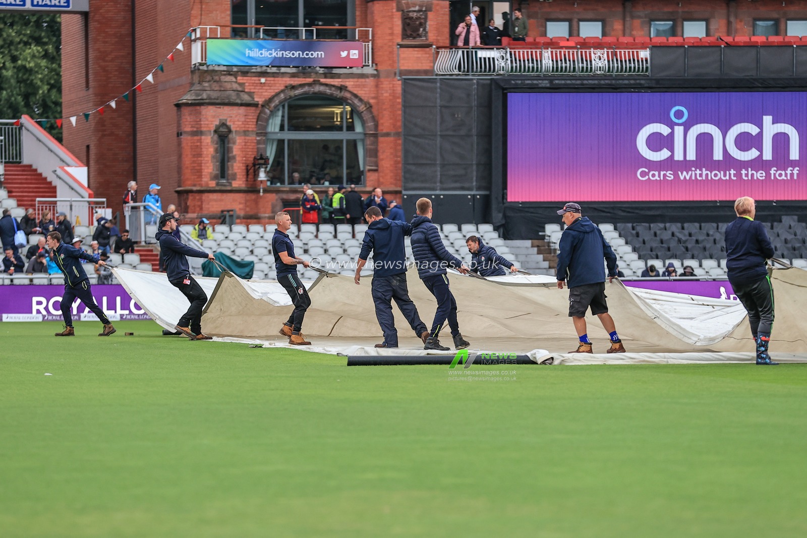The covers are coming off at Emirates Old Trafford as ground staff prepare the pitch after rain stops play