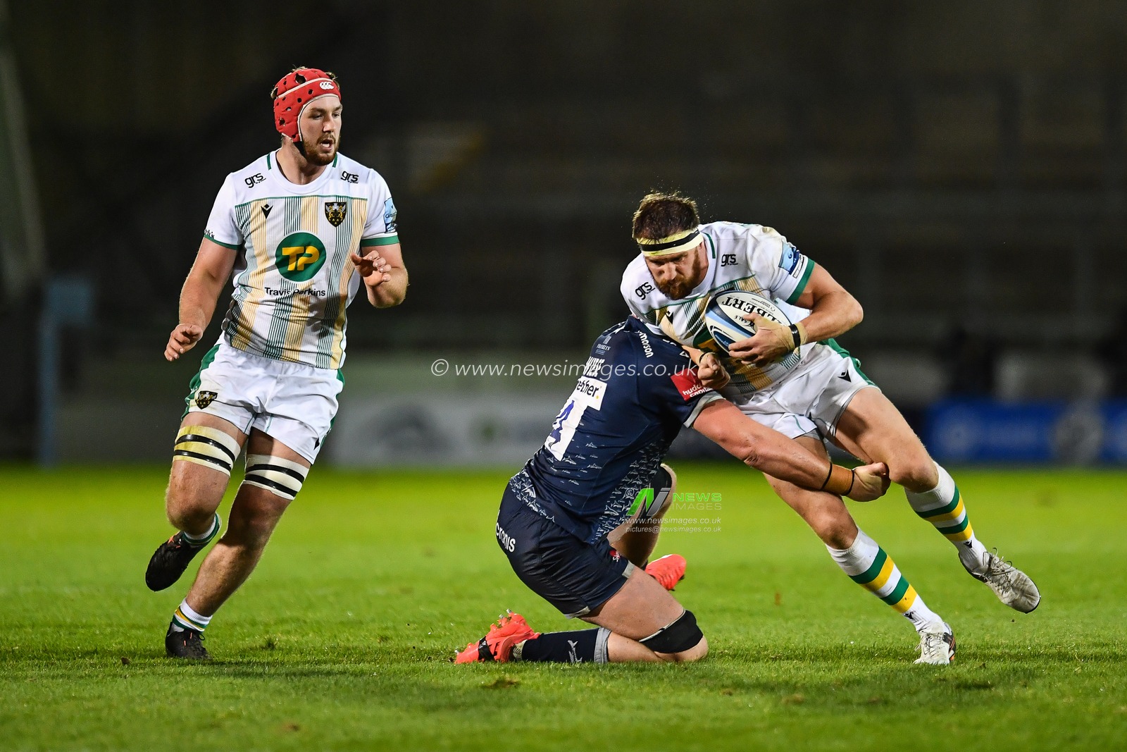 Tom Wood of Northampton Saints is tackled by Cobus Wiese of Sale Sharks