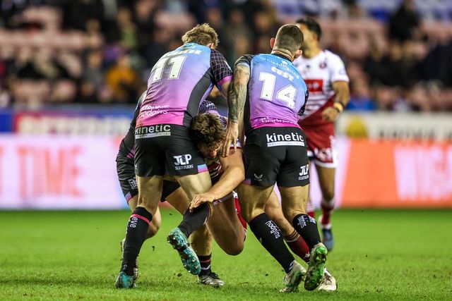 Ethan Havard of Wigan Warriors is tackled by Joe Batchelor of Hull FC and Cade Cust of Hull FC during the Betfred Super League match Wigan Warriors vs Hull FC at The Brick Community Stadium, Wigan, United Kingdom on 21 February 2026

(Photo by Alfie Cosgrove/News Images)