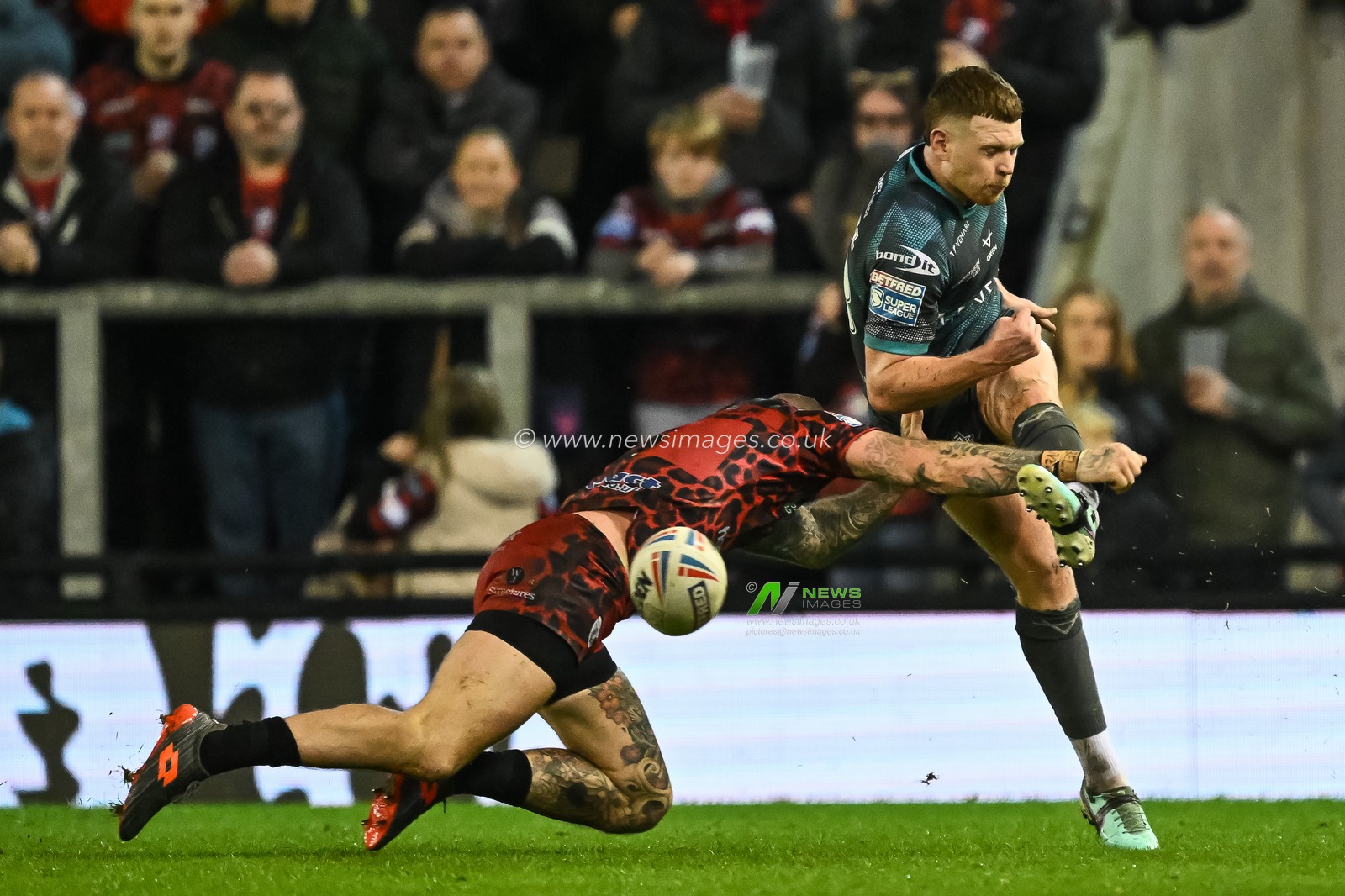 Olly Russell of Huddersfield Giants kicks up field despite pressure from Josh Charnley of Leigh Leopards during the Betfred Super League Round 1 match Leigh Leopards vs Huddersfield Giants at Leigh Sports Village, Leigh, United Kingdom, 16th February 2024

(Photo by Craig Thomas/News Images)