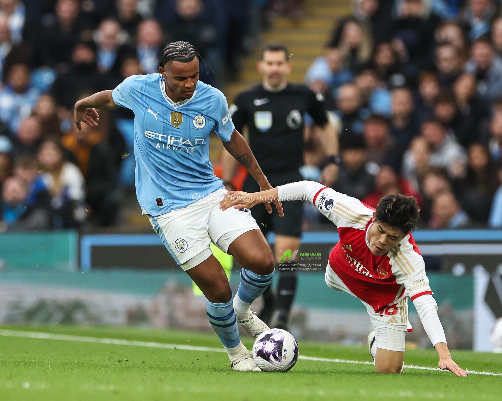 Takehiro Tomiyasu of Arsenal is tackled by Manuel Akanji of Manchester City during the Premier League match Manchester City vs Arsenal at Etihad Stadium, Manchester, United Kingdom, 31st March 2024

(Photo by Mark Cosgrove/News Images)