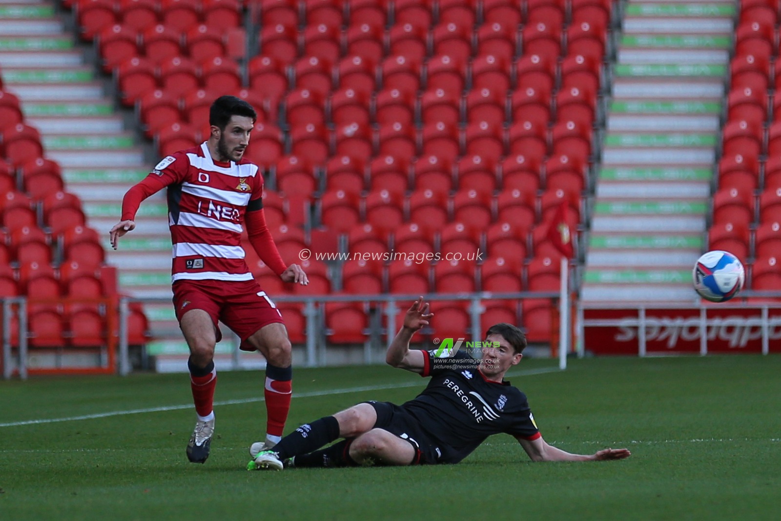 Danny Amos (16) of Doncaster Rovers is tackled by Conor McGrandles (18) of Lincoln City