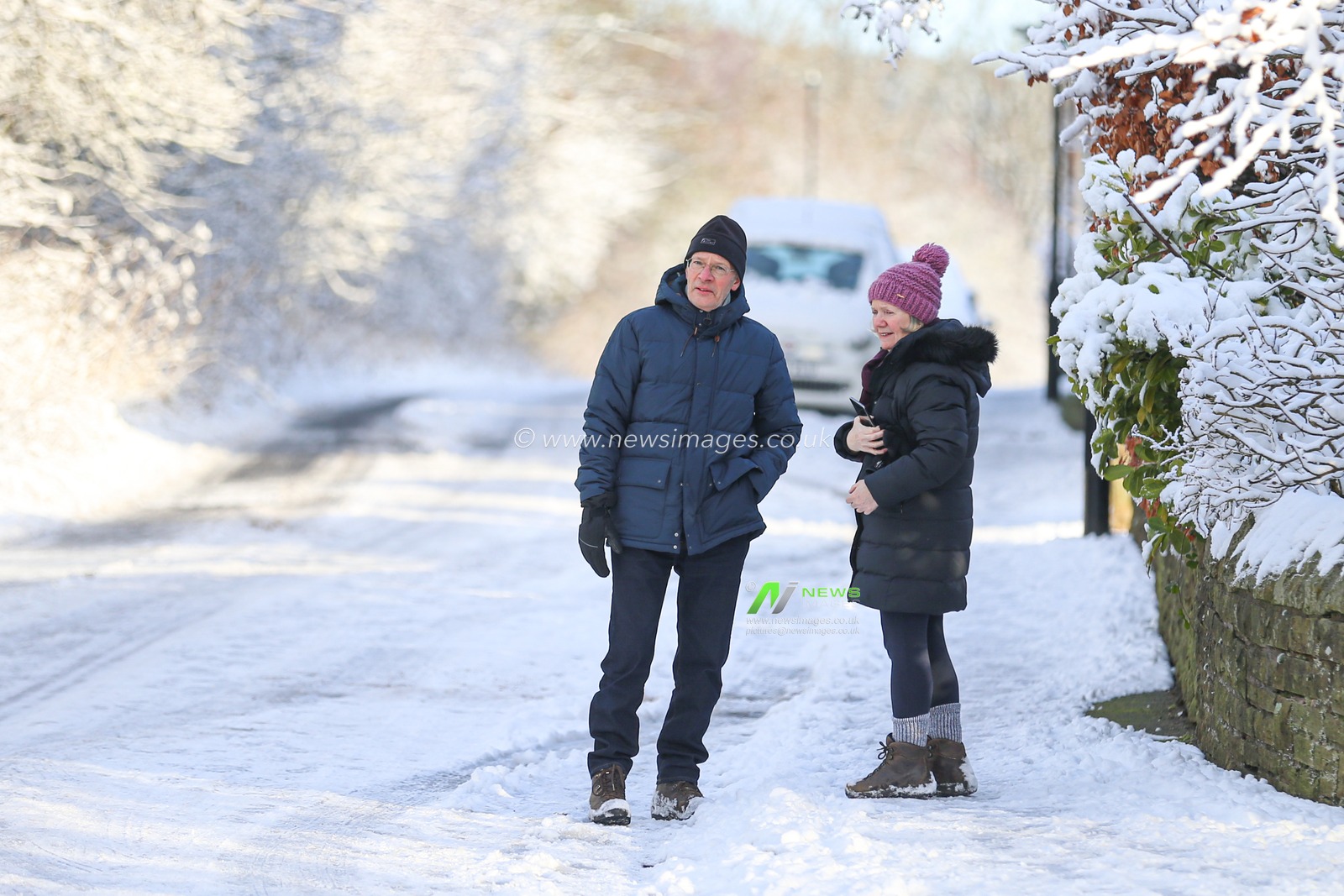 A couple are seen walking on an icy pavement after heavy snow fall in Dore, Sheffield