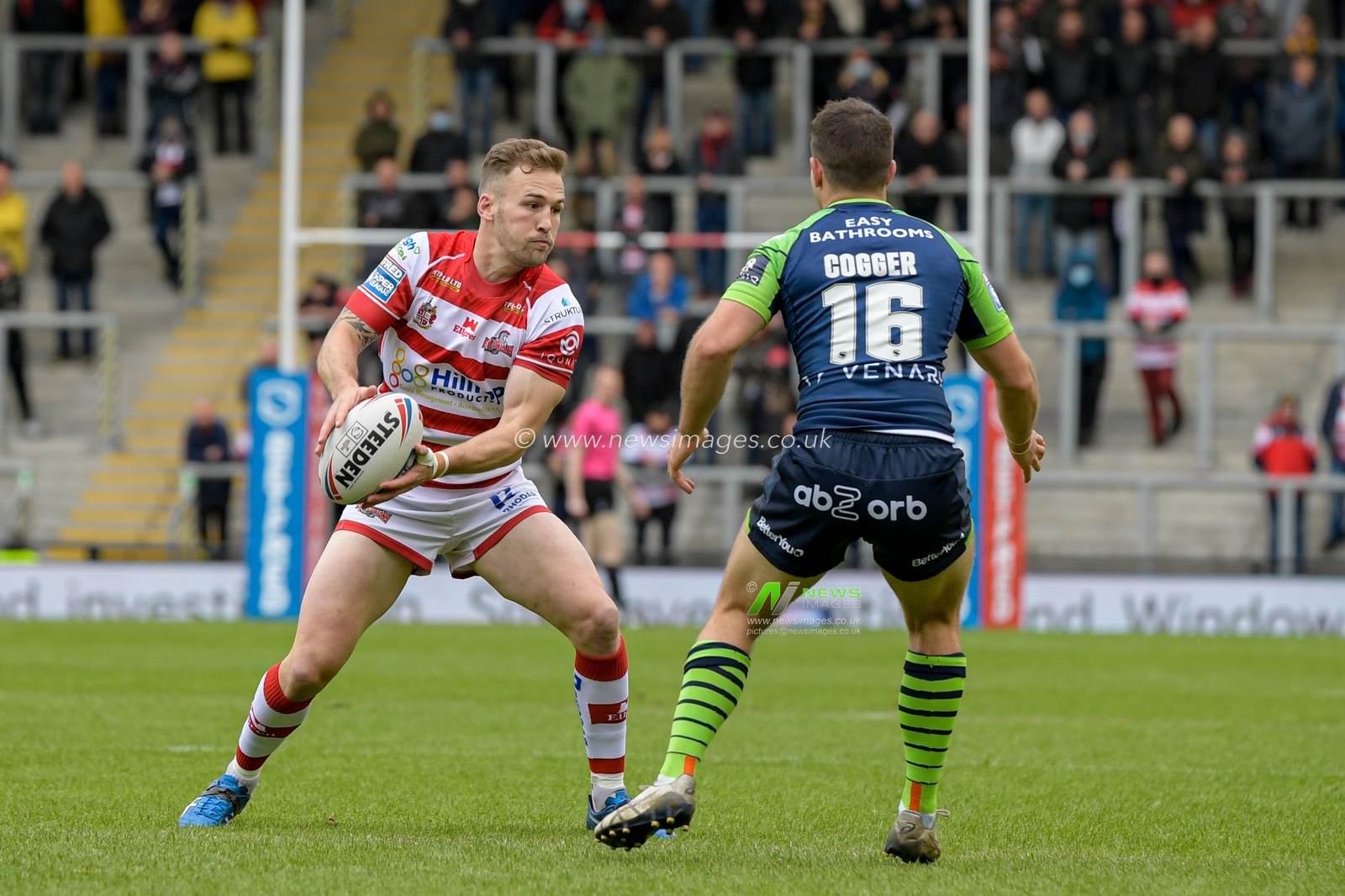 Ben Reynolds (30) of Leigh Centurions looks for a way past Jack Cogger (16) of Huddersfield Giants