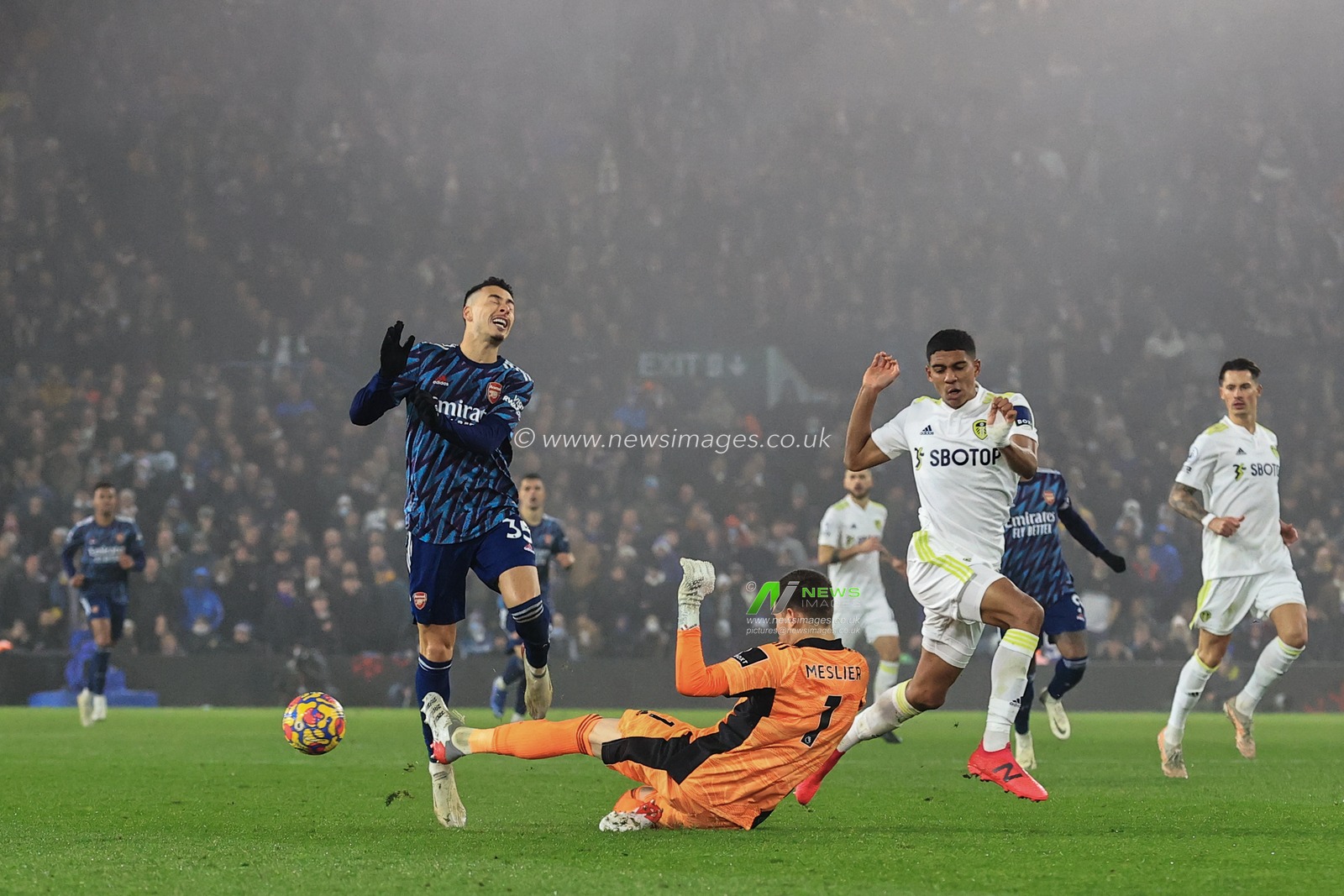Illan Meslier #1 of Leeds United slides in to win the ball from Gabriel Martinelli #35 of Arsenal