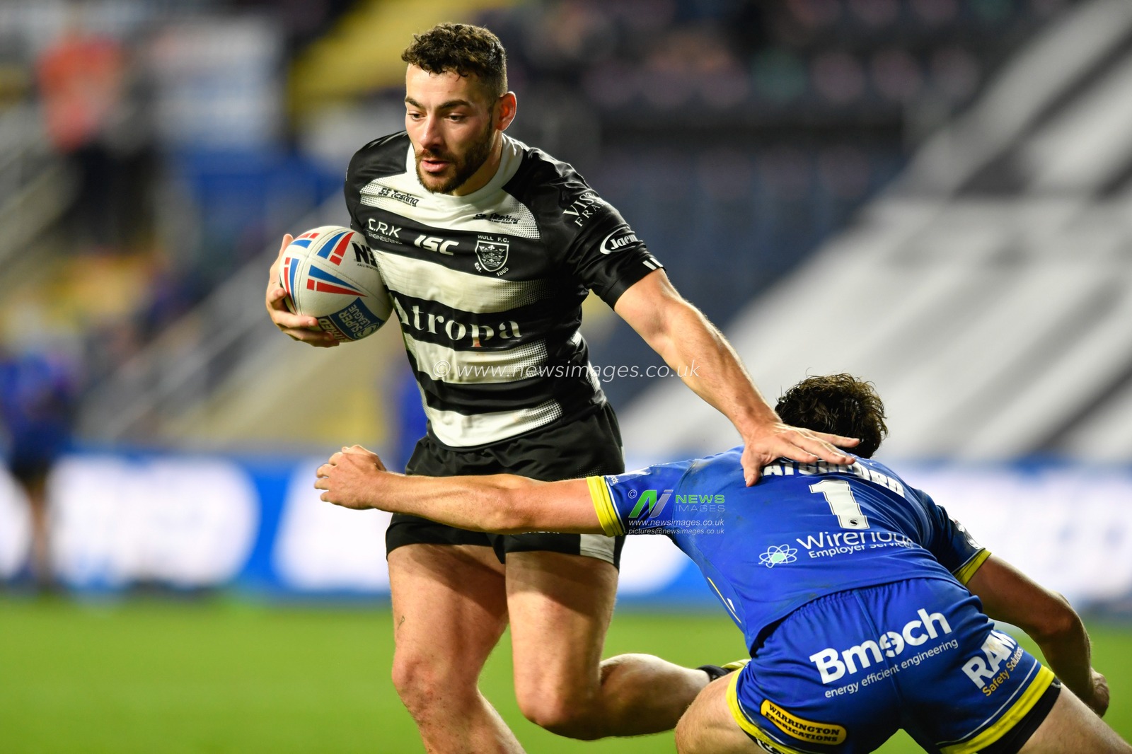 Jake Connor (6) of Hull FC is tackled by Stefan Ratchford (1) of Warrington Wolves
