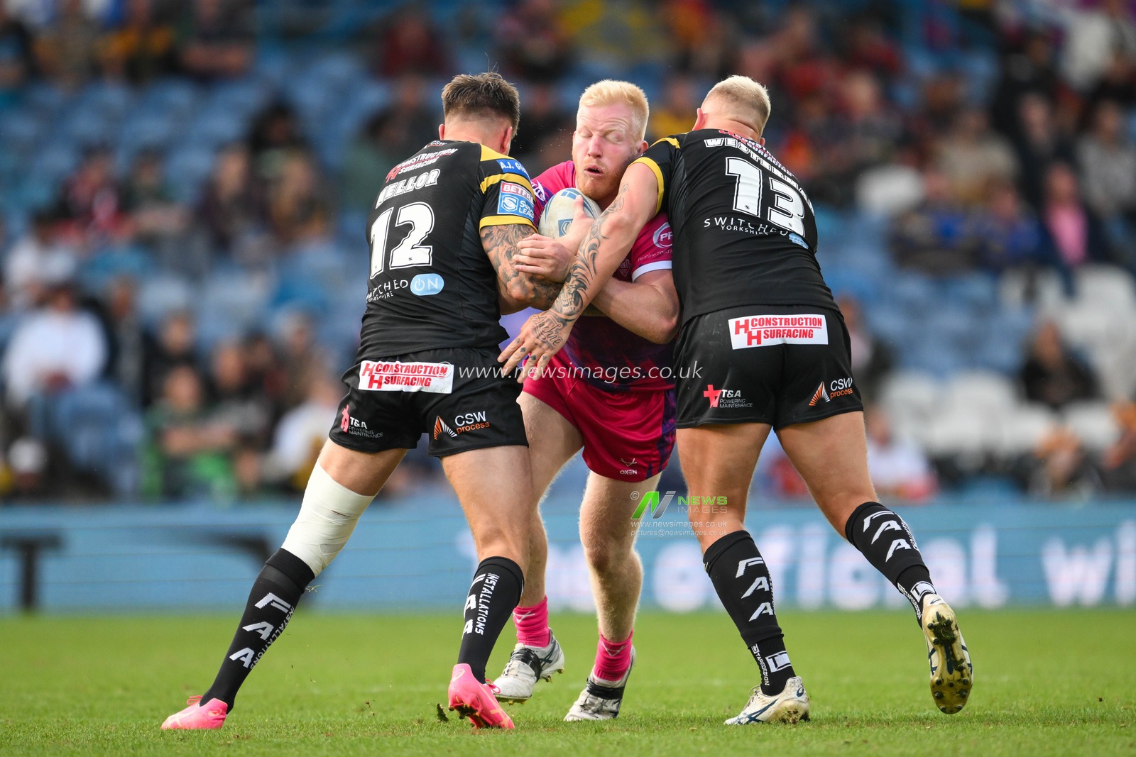 Matty English of Huddersfield Giants is tackled by Alex Mellor of Castleford Tigers and Joe Westerman of Castleford Tigers during the Magic Weekend match Huddersfield Giants vs Castleford Tigers at Elland Road, Leeds, United Kingdom, 18th August 2024

(Photo by Craig Thomas/News Images)