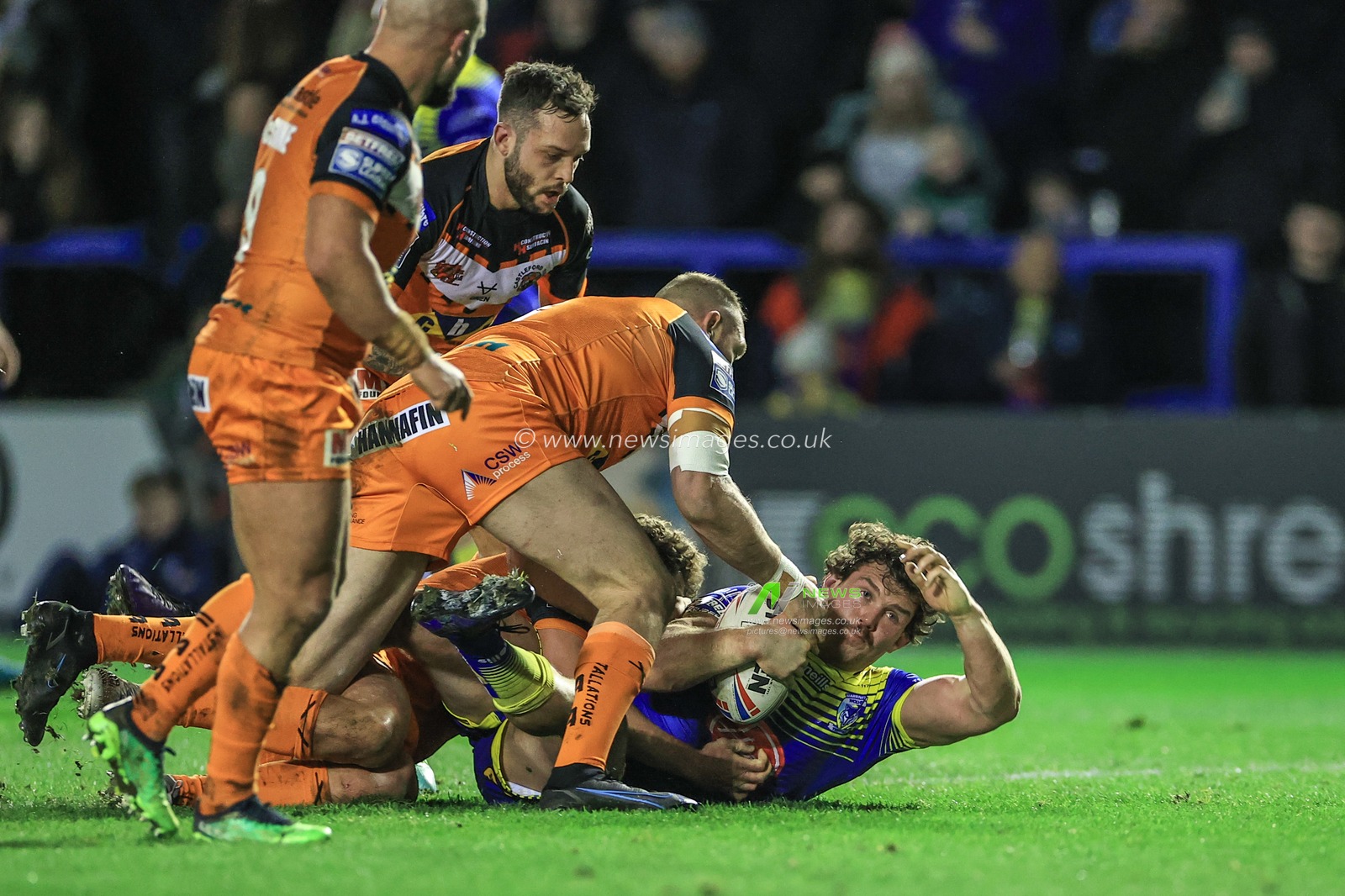 Rob Mulhern #19 of Warrington Wolves is tackled by Liam Watts #8 of Castleford Tigers