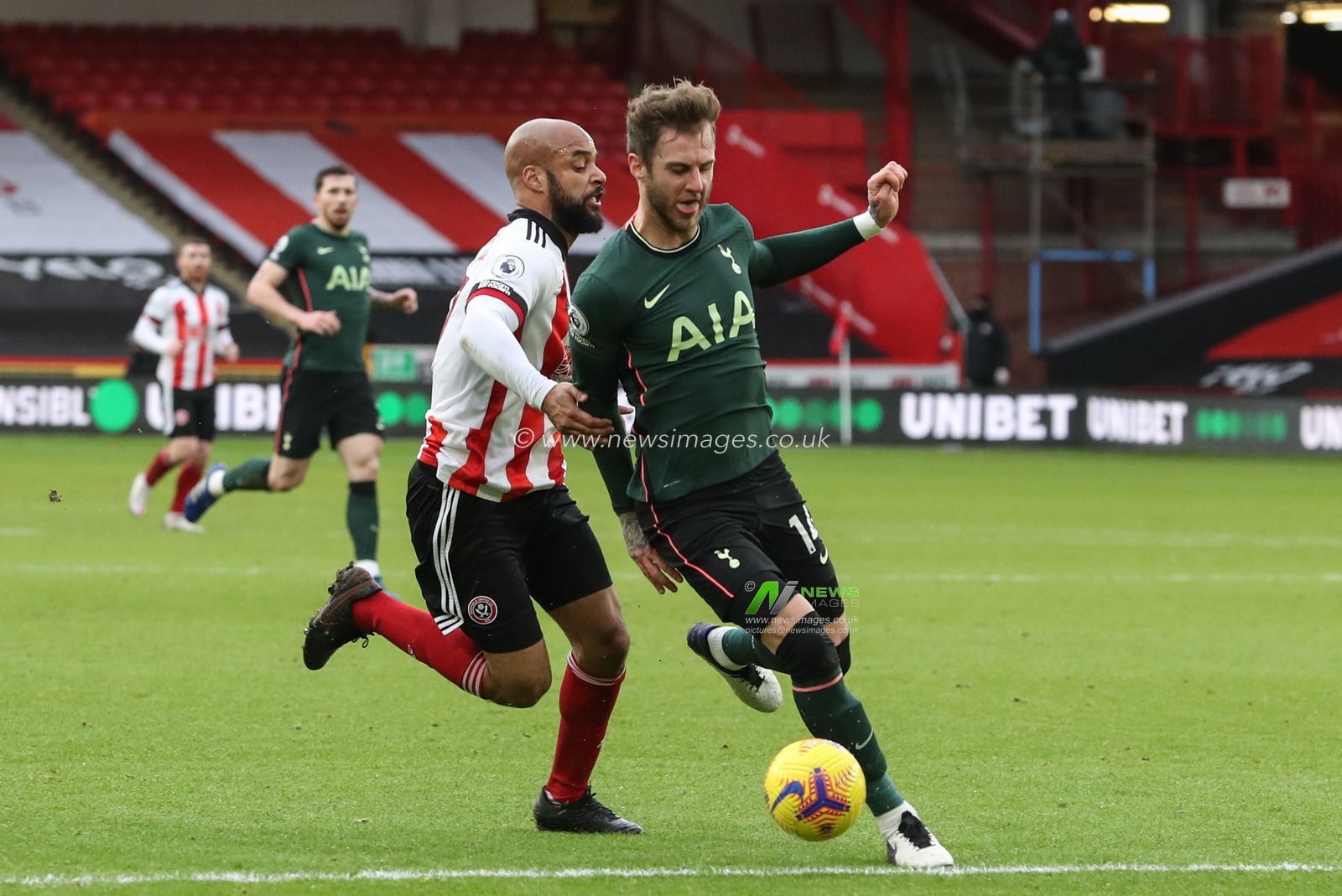 Joe Rodon #14 of Tottenham Hotspur tackles David McGoldrick #17 of Sheffield United who was on a break