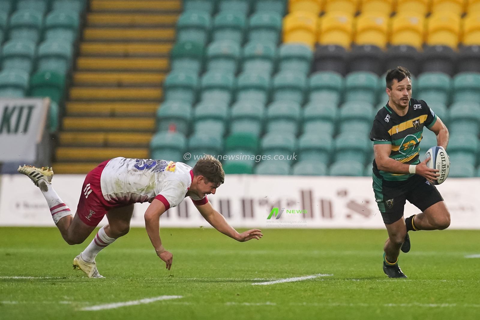 Tom Collins #11 of Northampton Saints gives the slip to Luke Northmore #13 of Harlequins