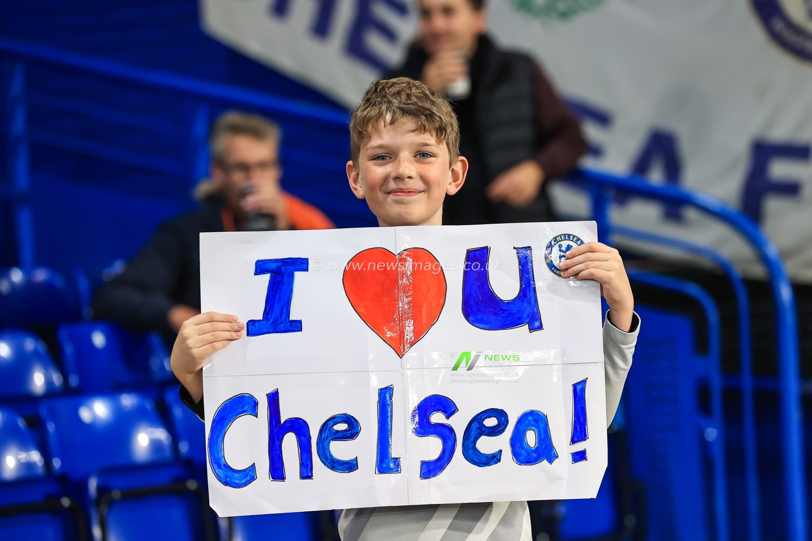 A young fan holds up a I love you Chelsea flag up
