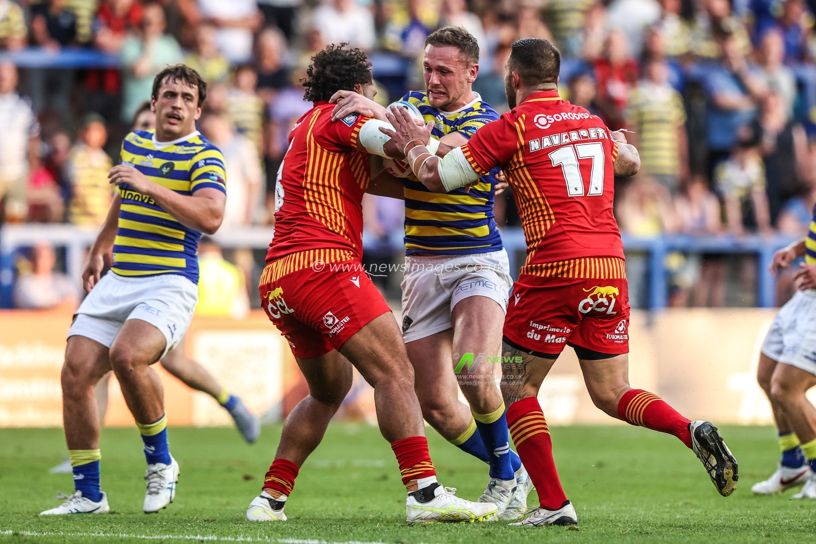 Ben Currie of Warrington Wolves is tackled by Romain Navarette of Catalans Dragons and Chris Satae of Catalans Dragons during the Betfred Super League round 16 match Warrington Wolves vs Catalans Dragons at The Halliwell Jones Stadium, Warrington, United Kingdom on 25 June 2026

(Photo by Alfie Cosgrove/News Images)