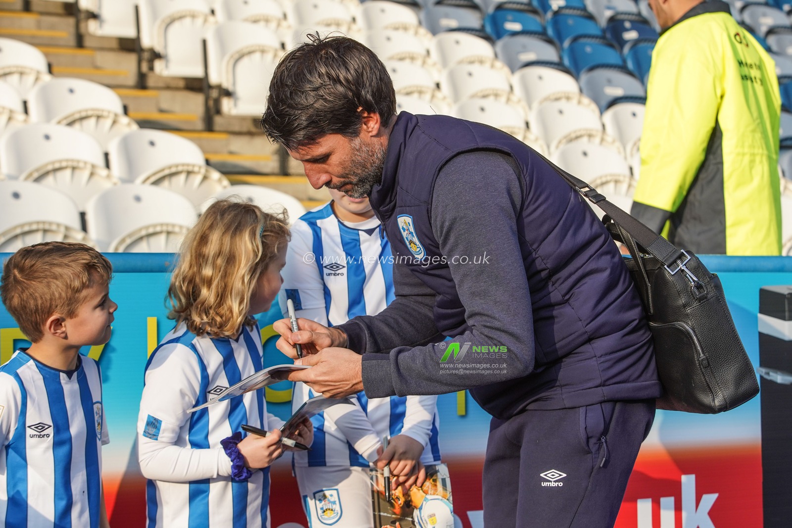 1st January 2020, John Smith's Stadium, Huddersfield, England; Sky Bet Championship, Huddersfield Town v Stoke City : Danny Cowley manager of Huddersfield Town signs the match program for young fans 

Credit: Kurt Fairhurst/News Images