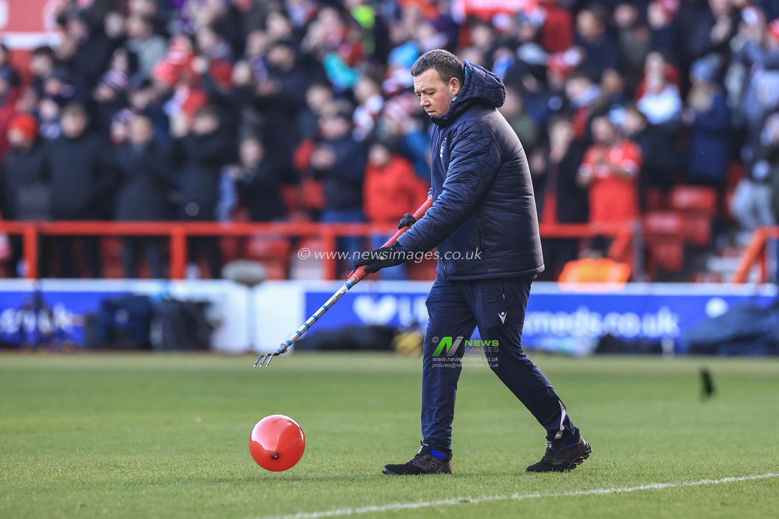 A ground staff pops a red balloon