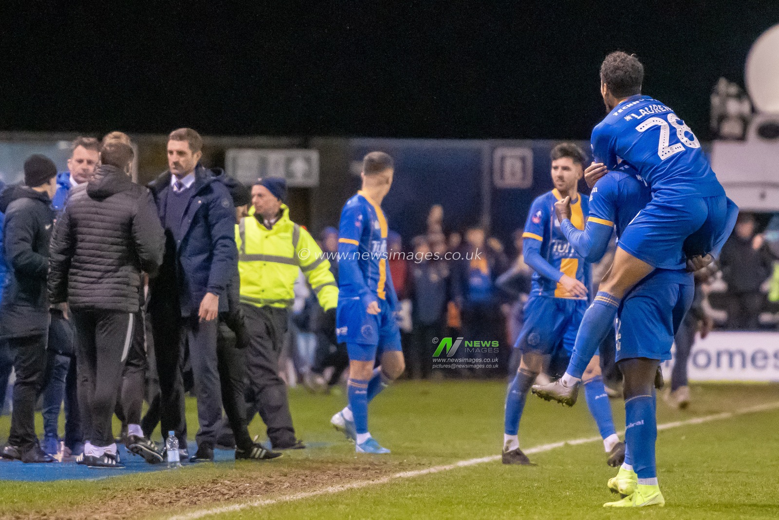 14th January 2020, Greenhous Meadow, Shrewsbury, England; Emirates FA Cup, Shrewsbury Town v Bristol City :
both goalscorer Aaron Pierre (02) of Shrewsbury Town and team mate Josh Laurent (28) of Shrewsbury Town celebrate winning the tie. Both Sam Ricketts Manager of Shrewsbury Town and Lee Johnson manager of Bristol City can be seen shaking hands after the final whistle in shot also.
Credit: Gareth Dalley/News Images