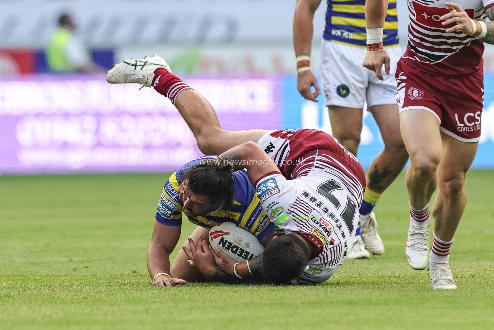 James Bentley of Warrington Wolves is tackled by Oliver Partington of Wigan Warriors during the Betfred Super League round 18 match Wigan Warriors vs Warrington Wolves at The Brick Community Stadium, Wigan, United Kingdom on 10 July 2026

(Photo by Mark Cosgrove/News Images)