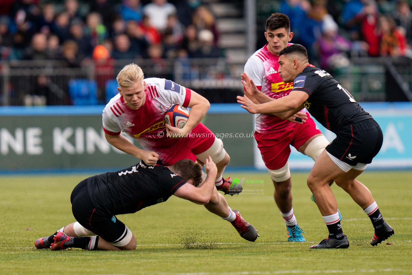 Hugh Tizard #4 of Harlequins is tackled by  Sean Reffell #7 of Saracens