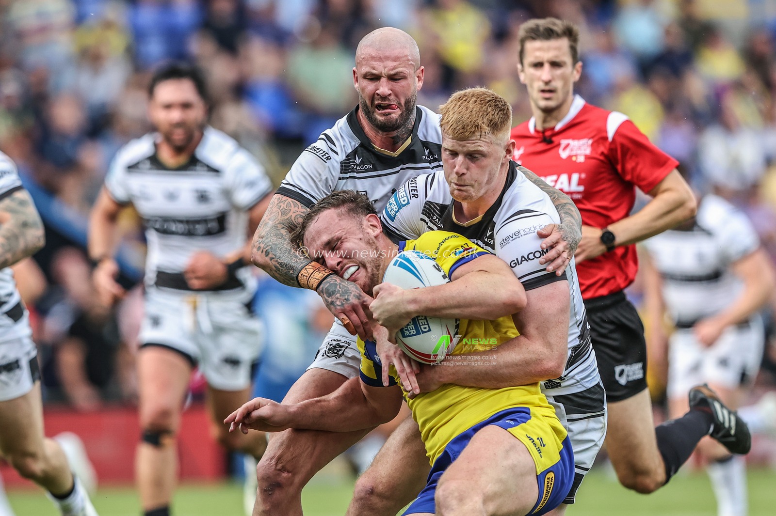 Ben Currie of Warrington Wolves is tackled during the Betfred Super League round 16 match Warrington Wolves vs Hull FC at Halliwell Jones Stadium, Warrington, United Kingdom, 28th June 2025

(Photo by Alfie Cosgrove/News Images)