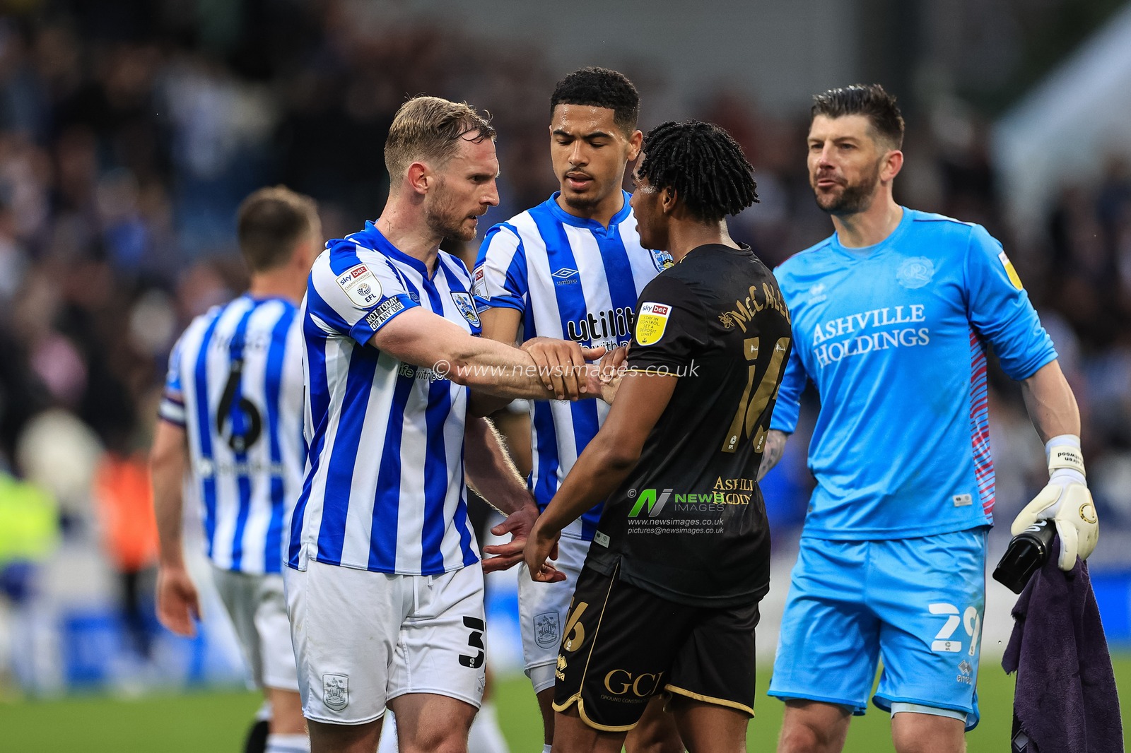 Tom Lees #32 of Huddersfield Town has a on pitch altercation with Sam McCallum #16 of Queens Park Rangers after the final whistle