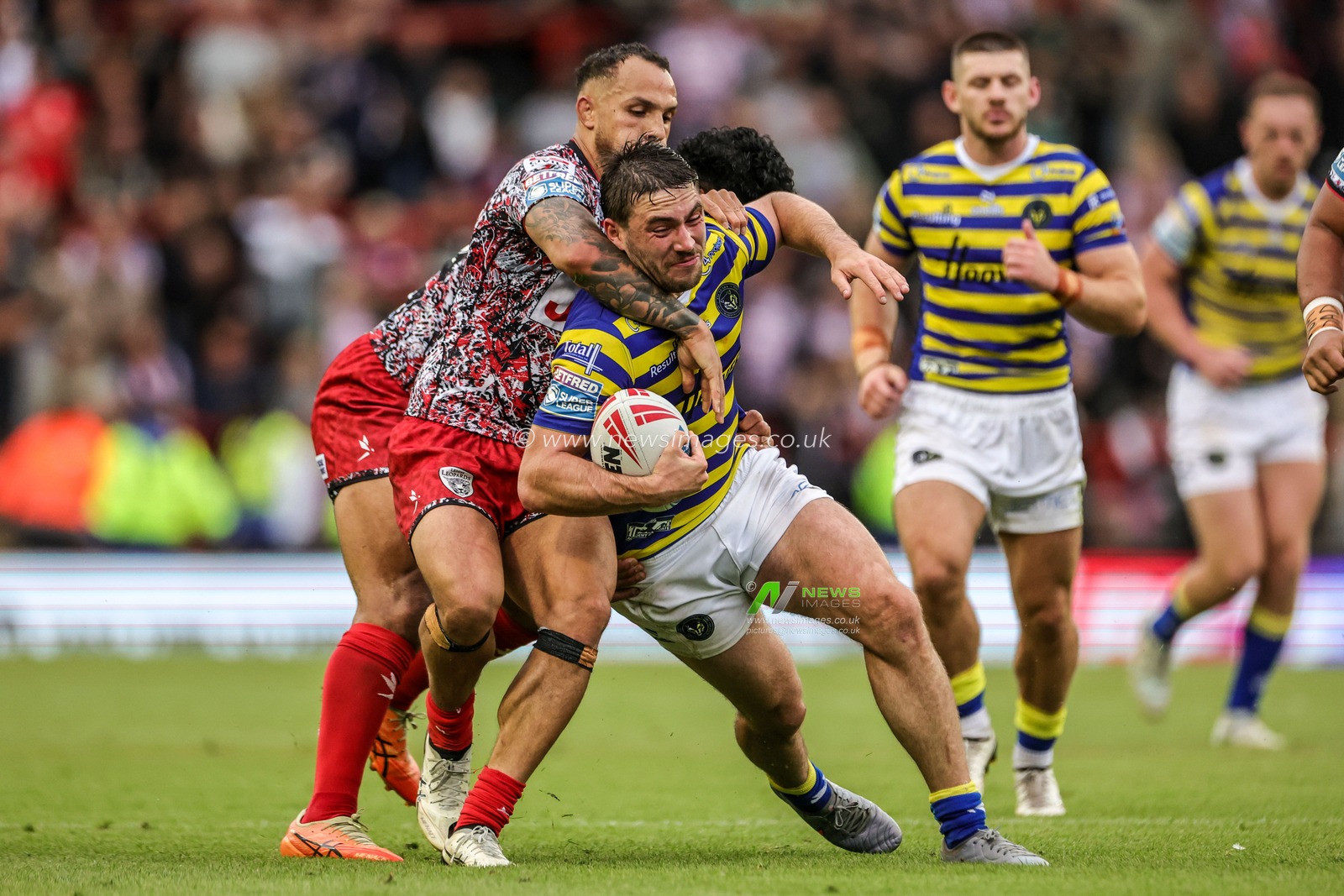 Adam Holroyd of Warrington Wolves is tackled by Liam Horne of Leigh Leopards and Isaac Liu of Leigh Leopards during the Betfred Super League round 20 match Leigh Leopards vs Warrington Wolves at Leigh Sports Village, Leigh, United Kingdom on 25 July 2026

(Photo by Alfie Cosgrove/News Images)