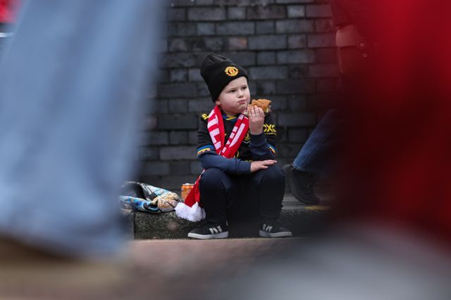 A young Manchester United fans sits in the road curb as he grabs a bite to eat during the Premier League match Manchester United vs Crystal Palace at Old Trafford, Manchester, United Kingdom on 01 March 2026

(Photo by Mark Cosgrove/News Images)