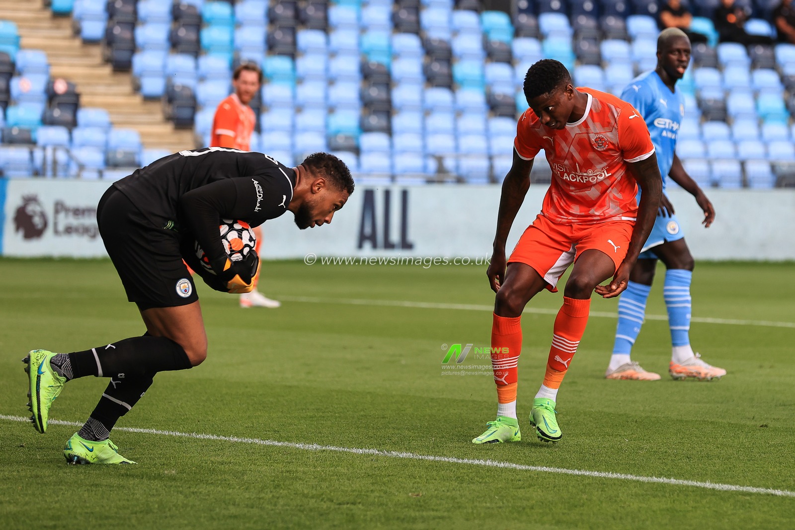 Zack Steffen #13 of Manchester City collects the ball ahead of Marvin Ekpiteta of Blackpool