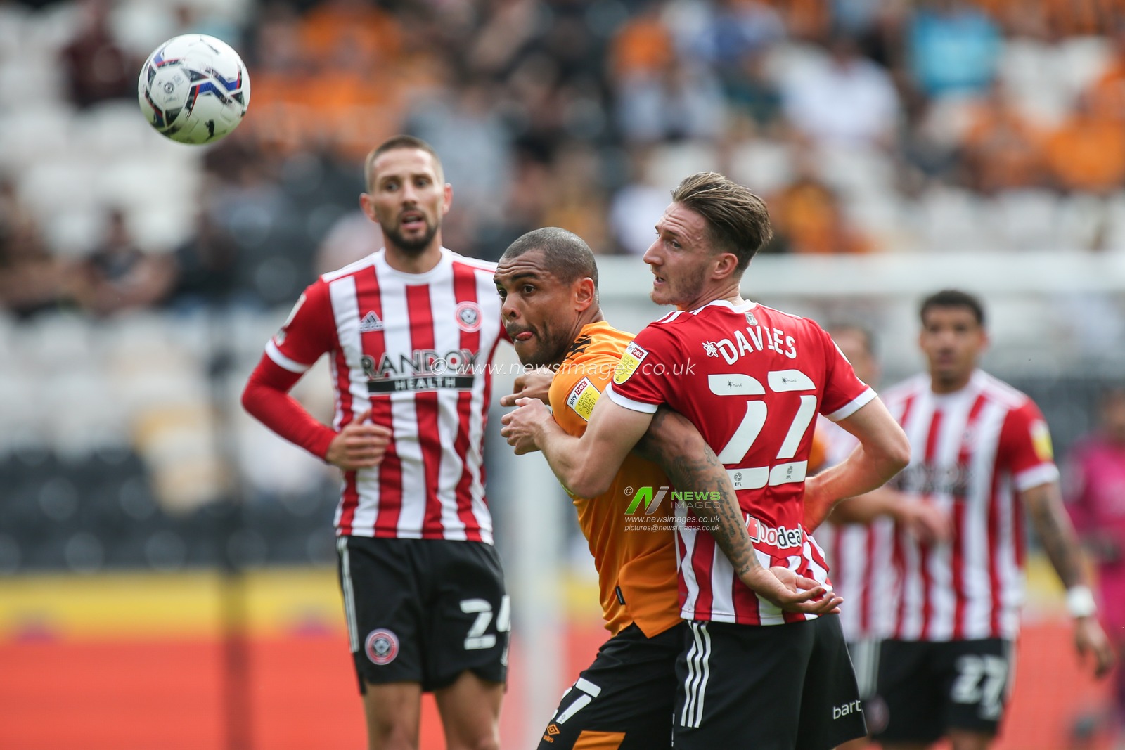 Josh Magennis #27 of Hull City challenges for the ball with Ben Davies #22 of Sheffield United
