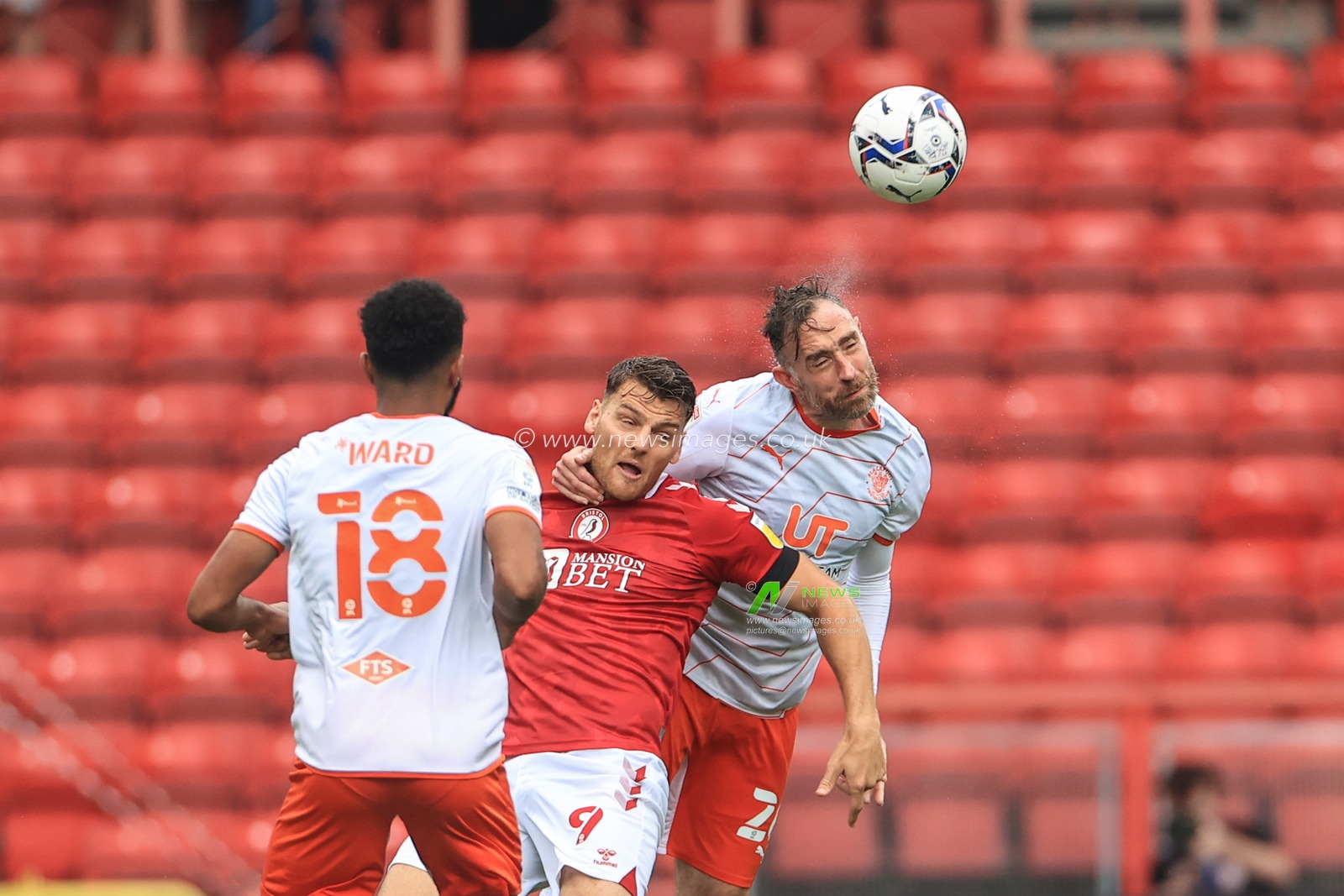 Richard Keogh #26 of Blackpool heads clear as Famara Diedhiou #9 of Bristol City pressures