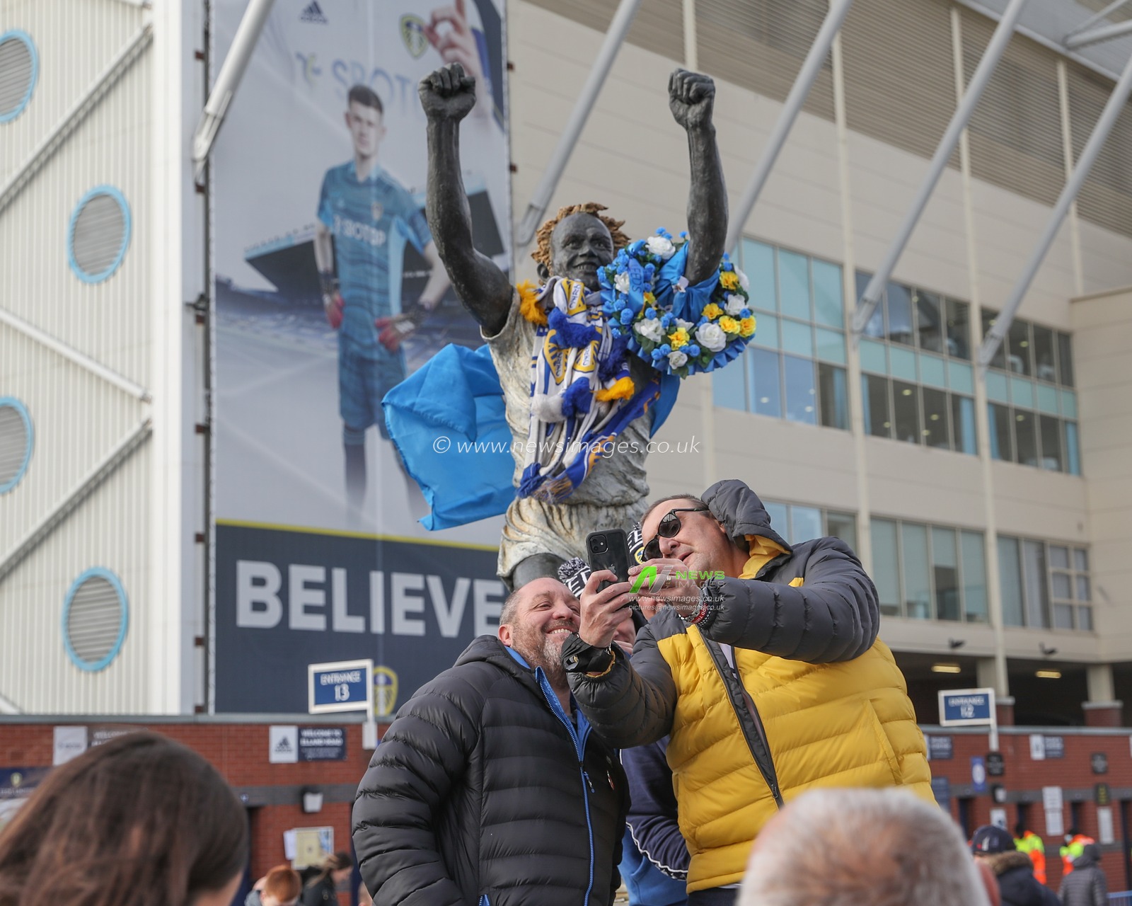 Leeds fans have their picture take at the Billy Bremner statue at Elland Road