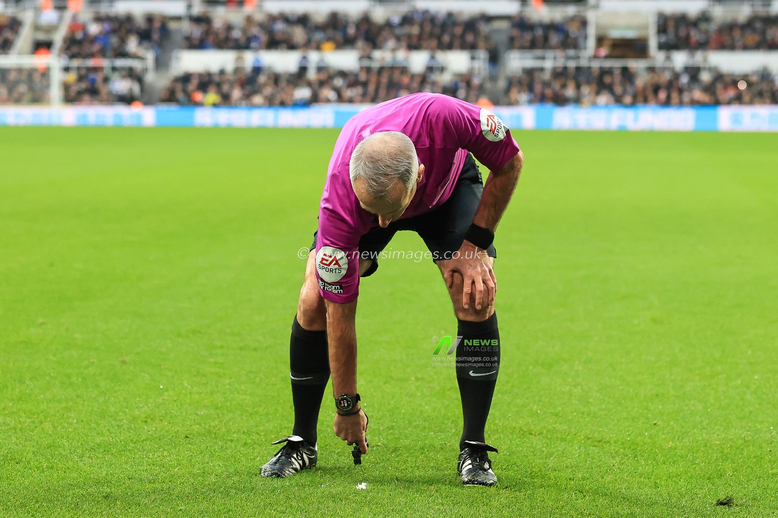 Referee Martin Atkinson marks the spot for a free kick