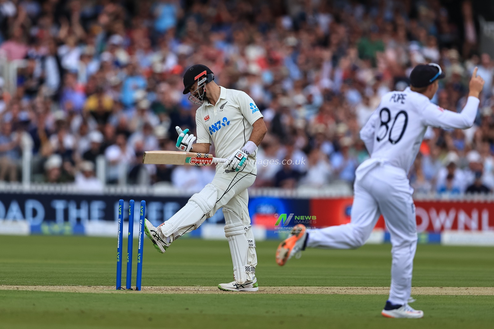 Daryl Mitchell #75 of New Zealand kicks the wicket as heâ€™s bowled out