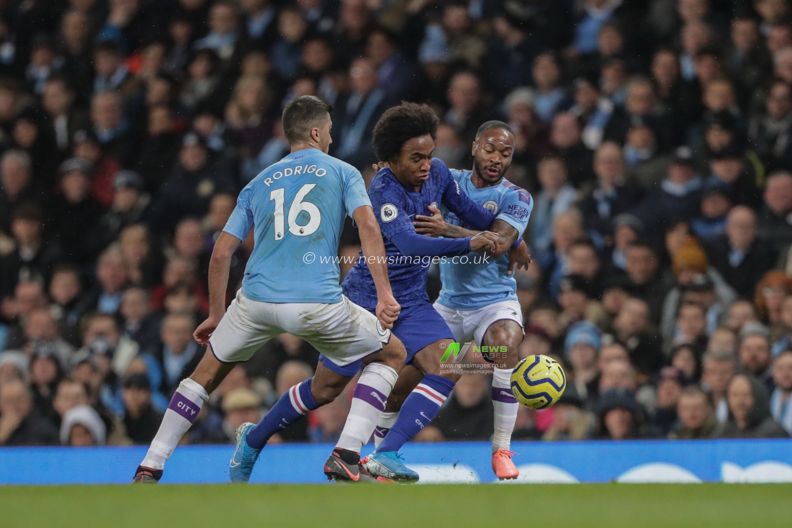 23rd November 2019, Etihad Stadium, Manchester, England; Premier League, Manchester City v Chelsea : Willian (10) of Chelsea looks to breaks through Raheem Sterling (7) of Manchester City and Rodrigo (16) of Manchester City 

Credit: Mark Cosgrove/News Images