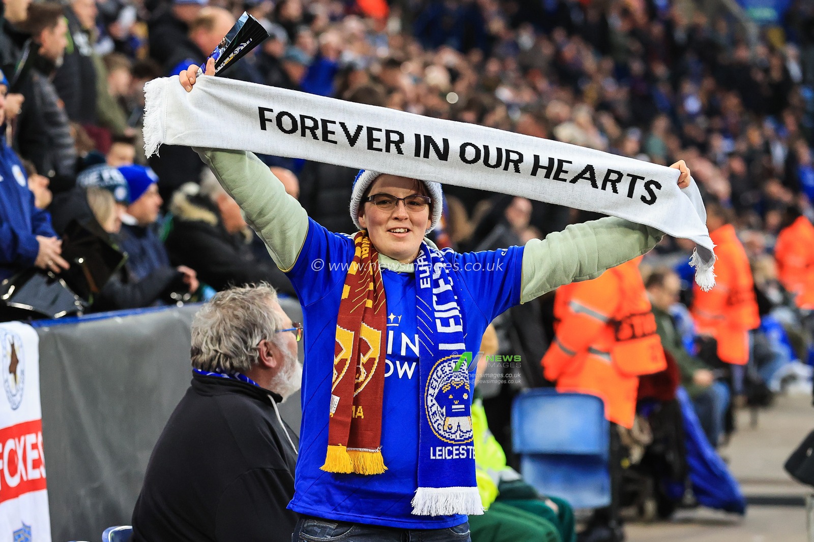 A Leicester City holds up a scarf before the game