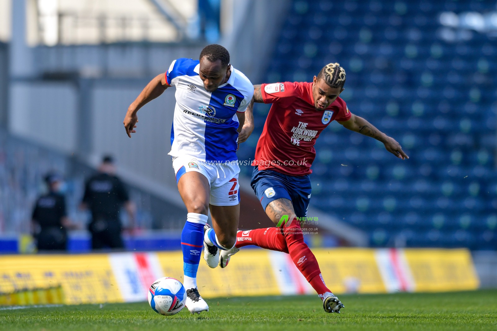 Ryan Nyambe #2 of Blackburn Rovers and Juninho Bacuna #7 of Huddersfield Town challenge for the ball