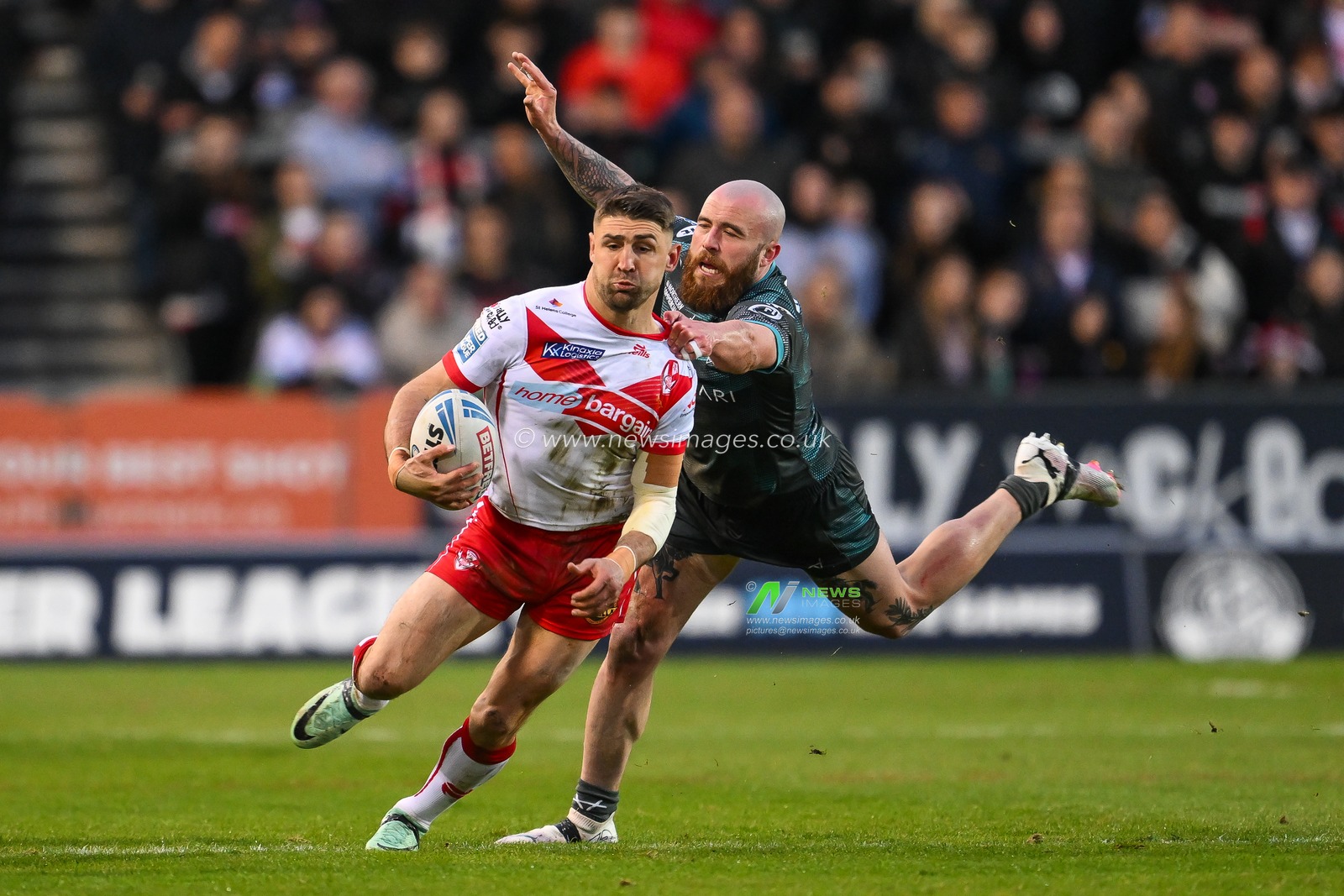 Tommy Makinson of St. Helens evades the tackle of Jake Bibby of Huddersfield Giants during the Betfred Super League Round 9 match St Helens vs Huddersfield Giants at Totally Wicked Stadium, St Helens, United Kingdom, 25th April 2024

(Photo by Craig Thomas/News Images)